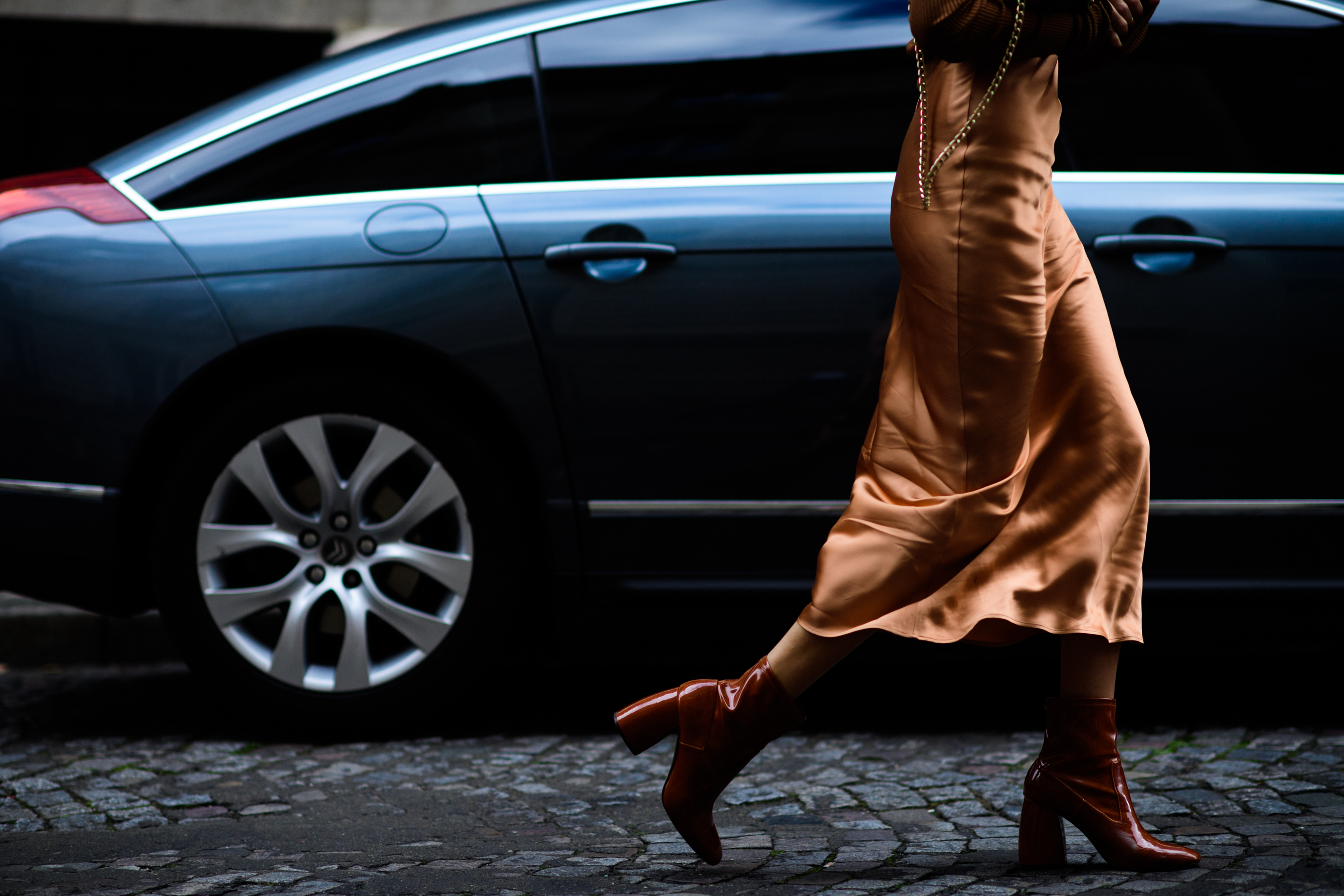 Closeup of French blogger in bronze dress and boots