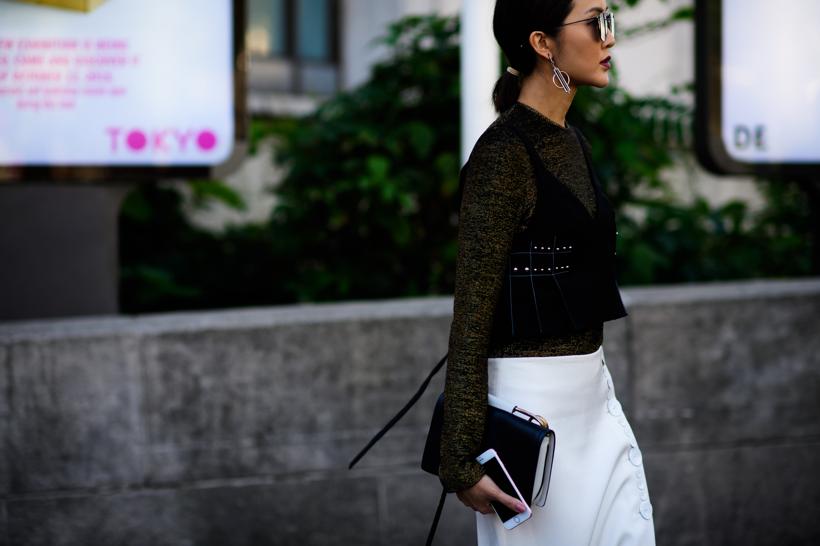 Woman wearing black top and white skirt