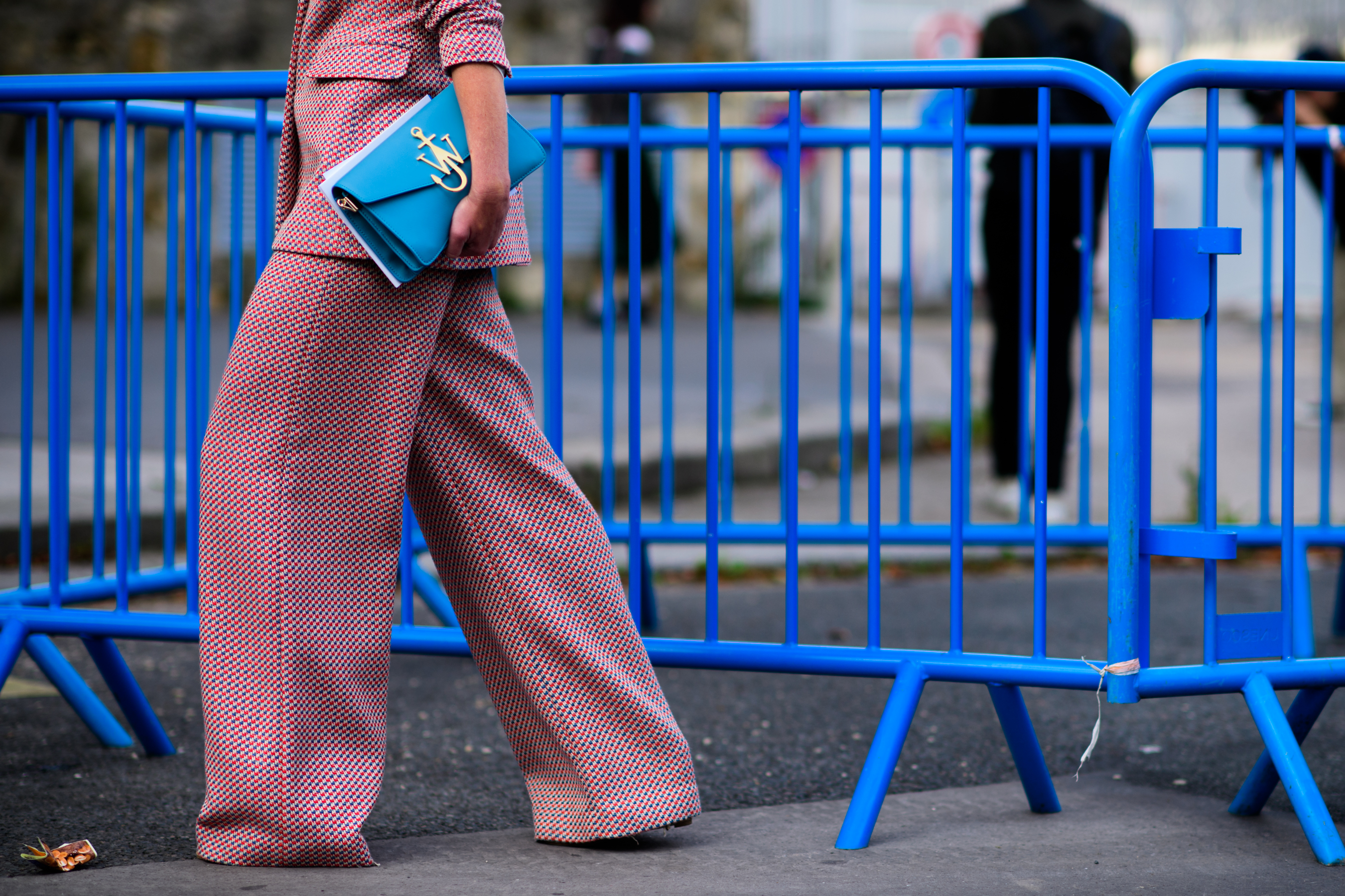 Closeup of woman in red check outfit and blue bag