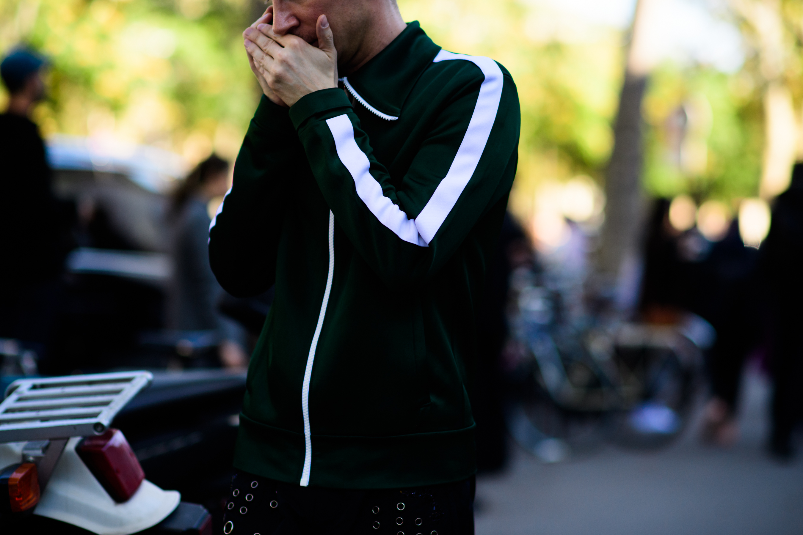 Man talking on phone in green and white track jacket