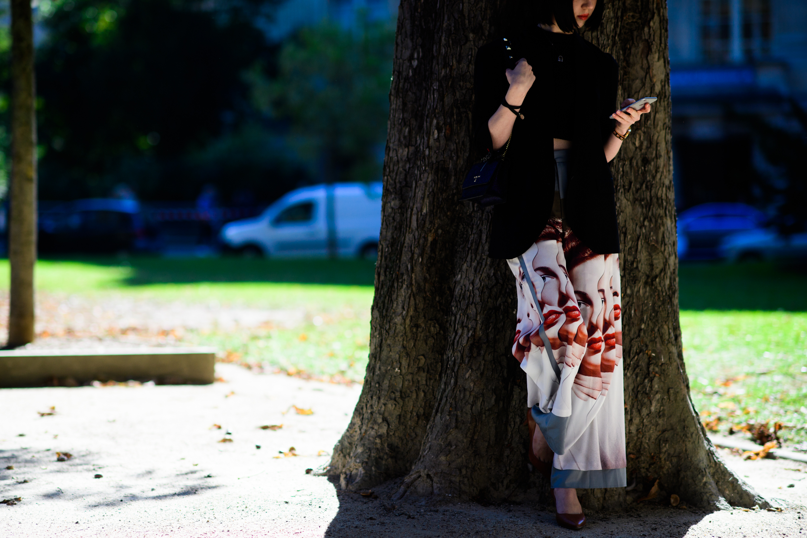 Woman leaning on tree in white skirt