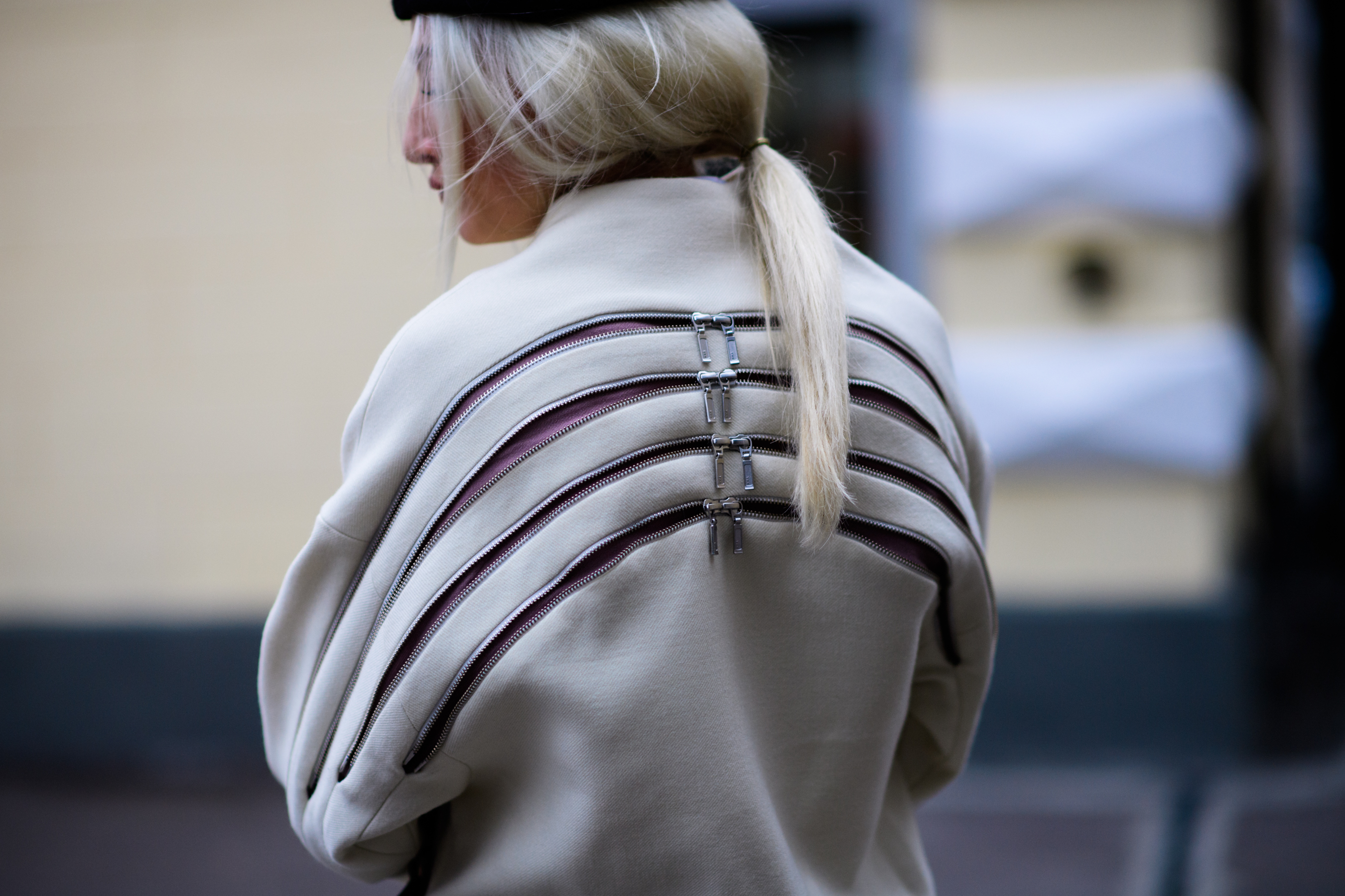 Blonde DJ wearing coat with zippers