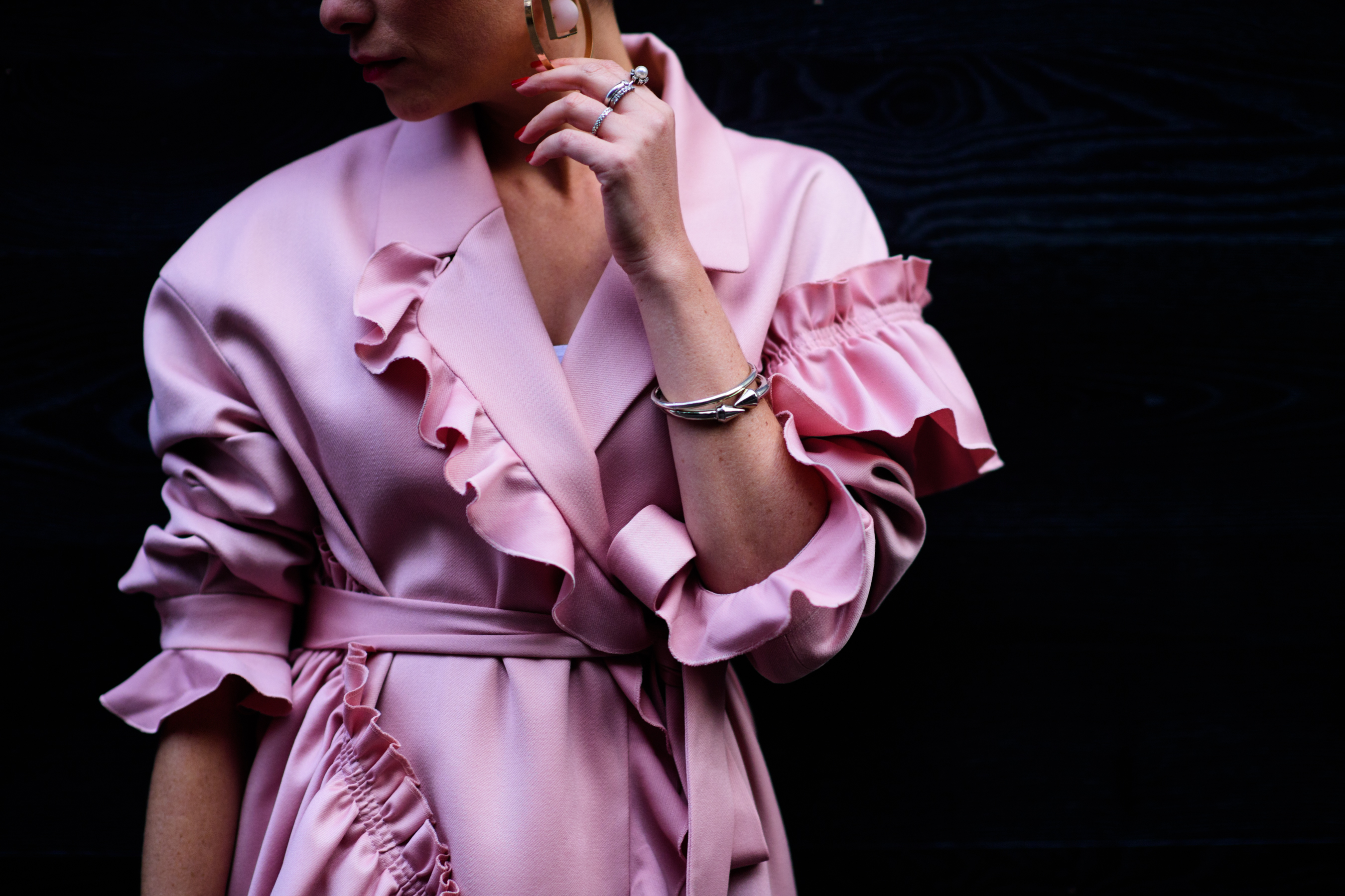 Woman wearing pink coat with ruffles