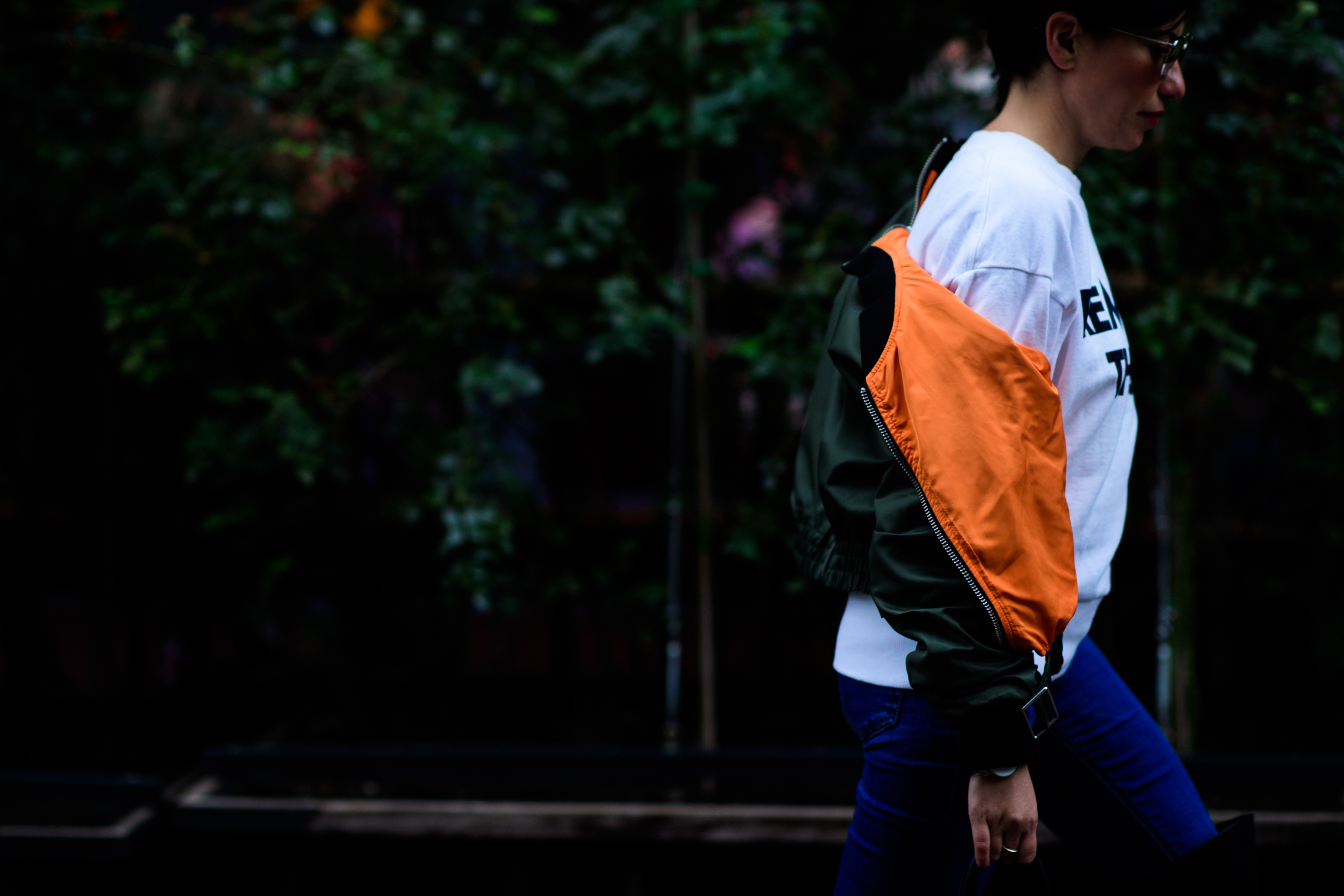 Woman wearing orange and green bomber jacket
