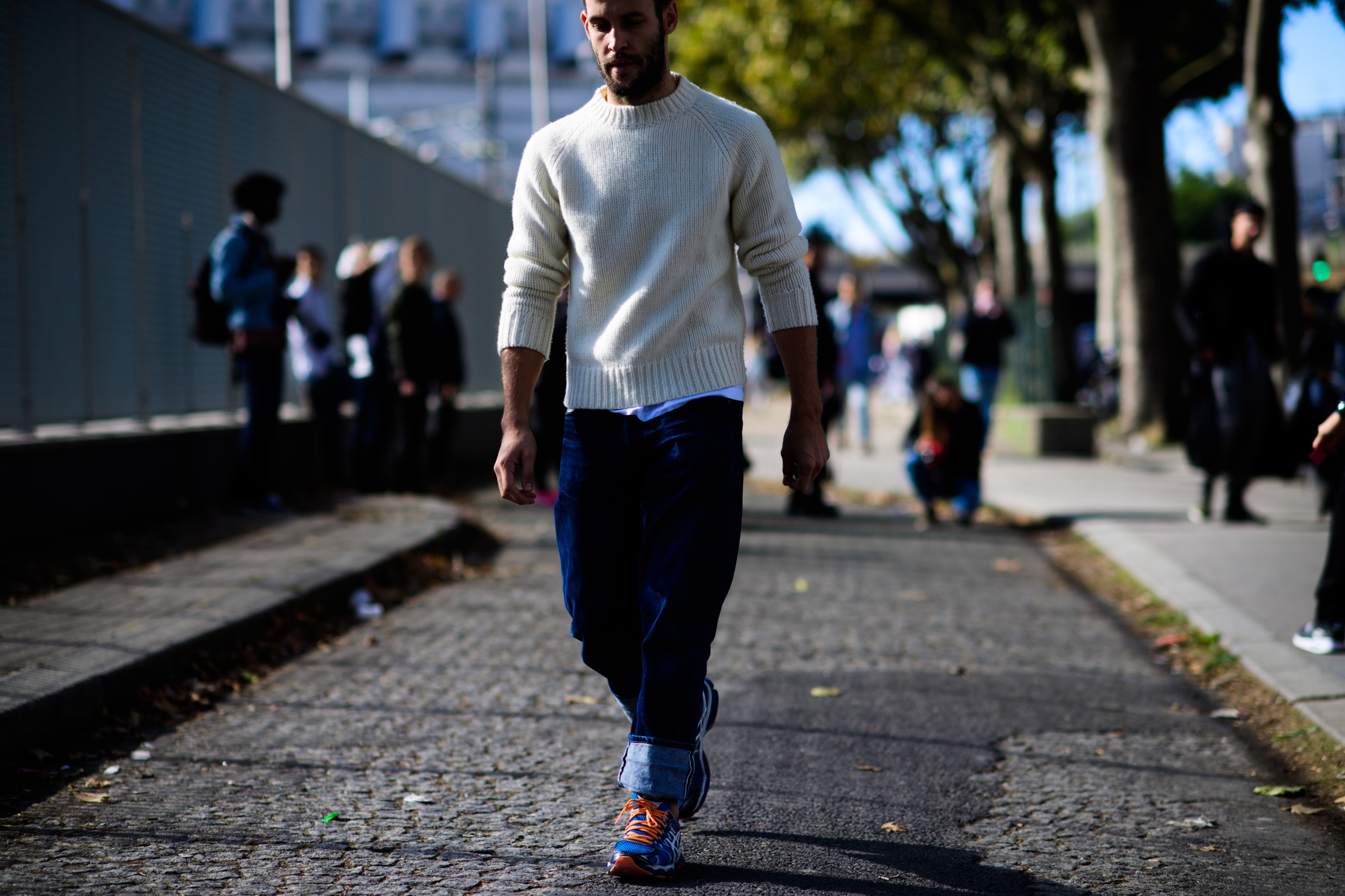 French designer wearing white knit jumper