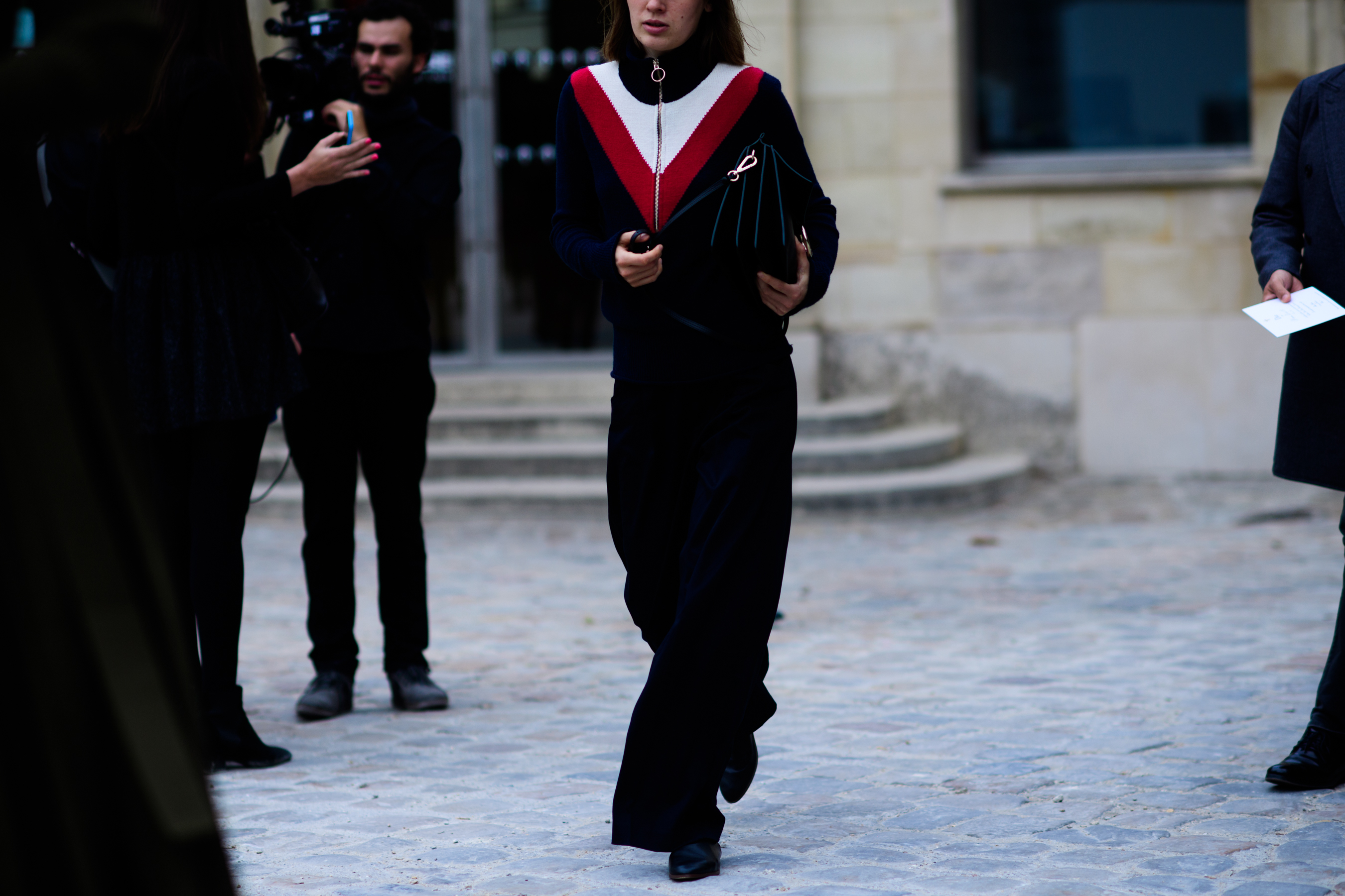 Russian stylist wearing black top with red and white detail