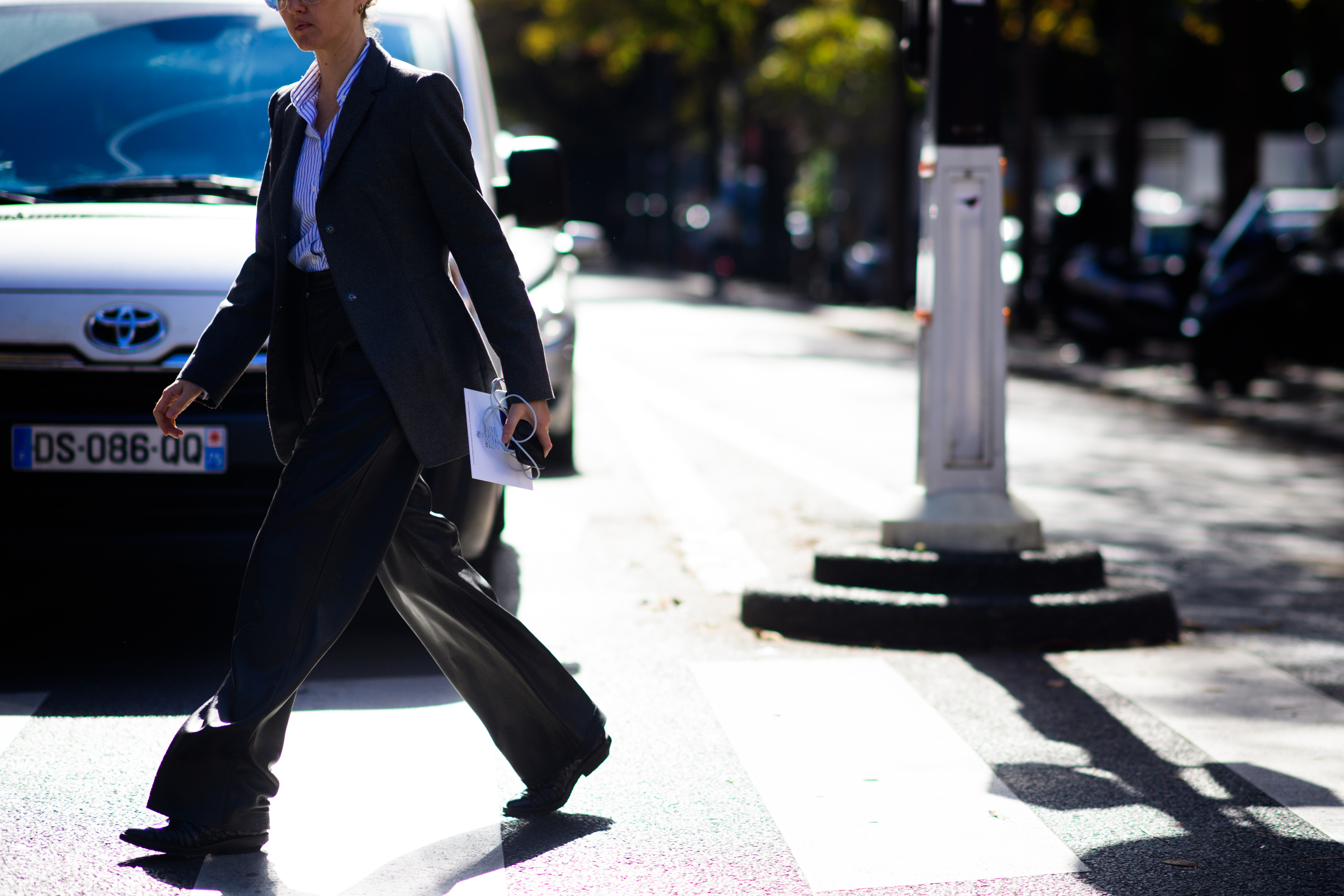Stylist crossing road in harsh sunlight