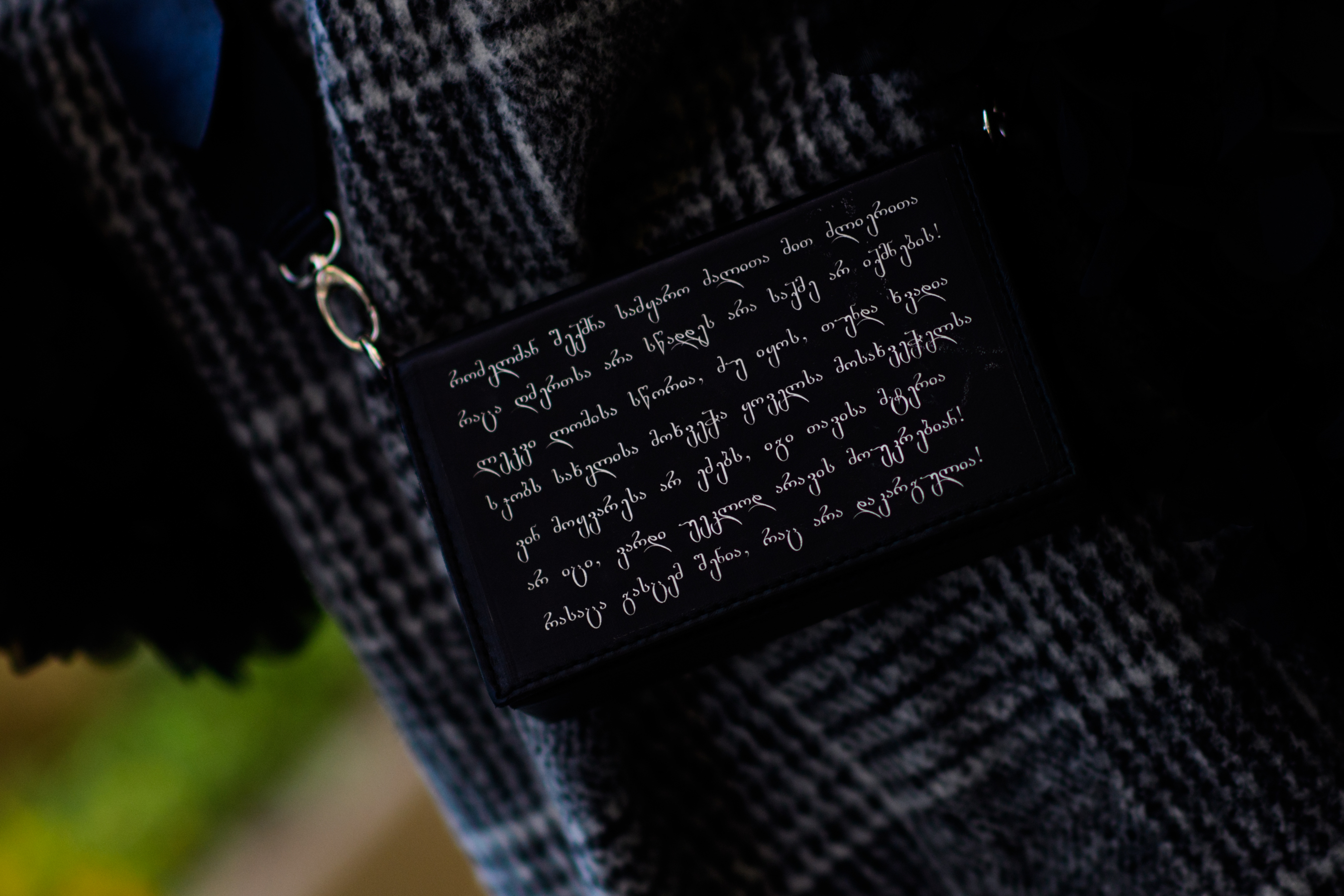 Woman with bag covered in Georgian writing