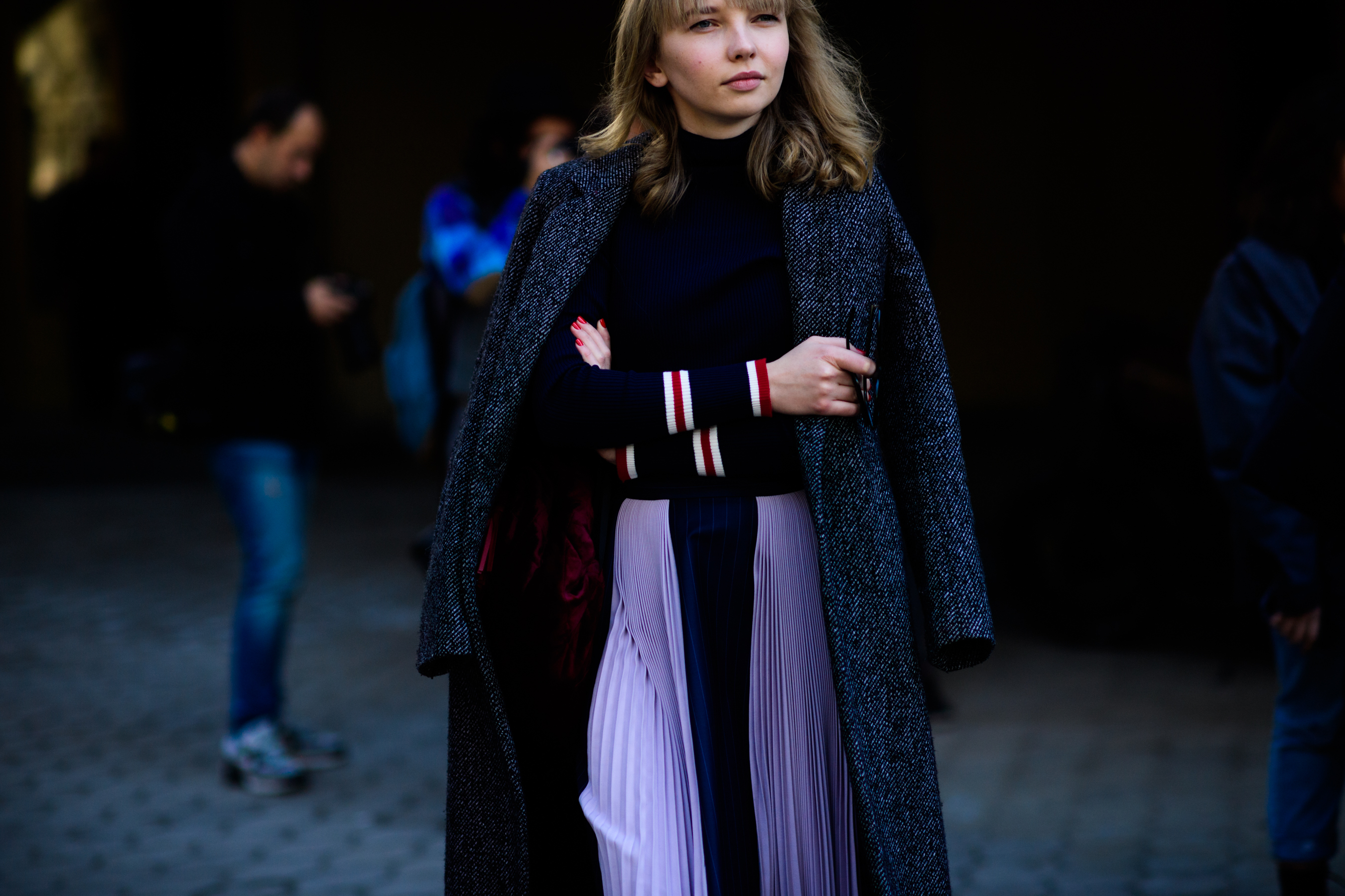 Woman wearing coat and pleated skirt