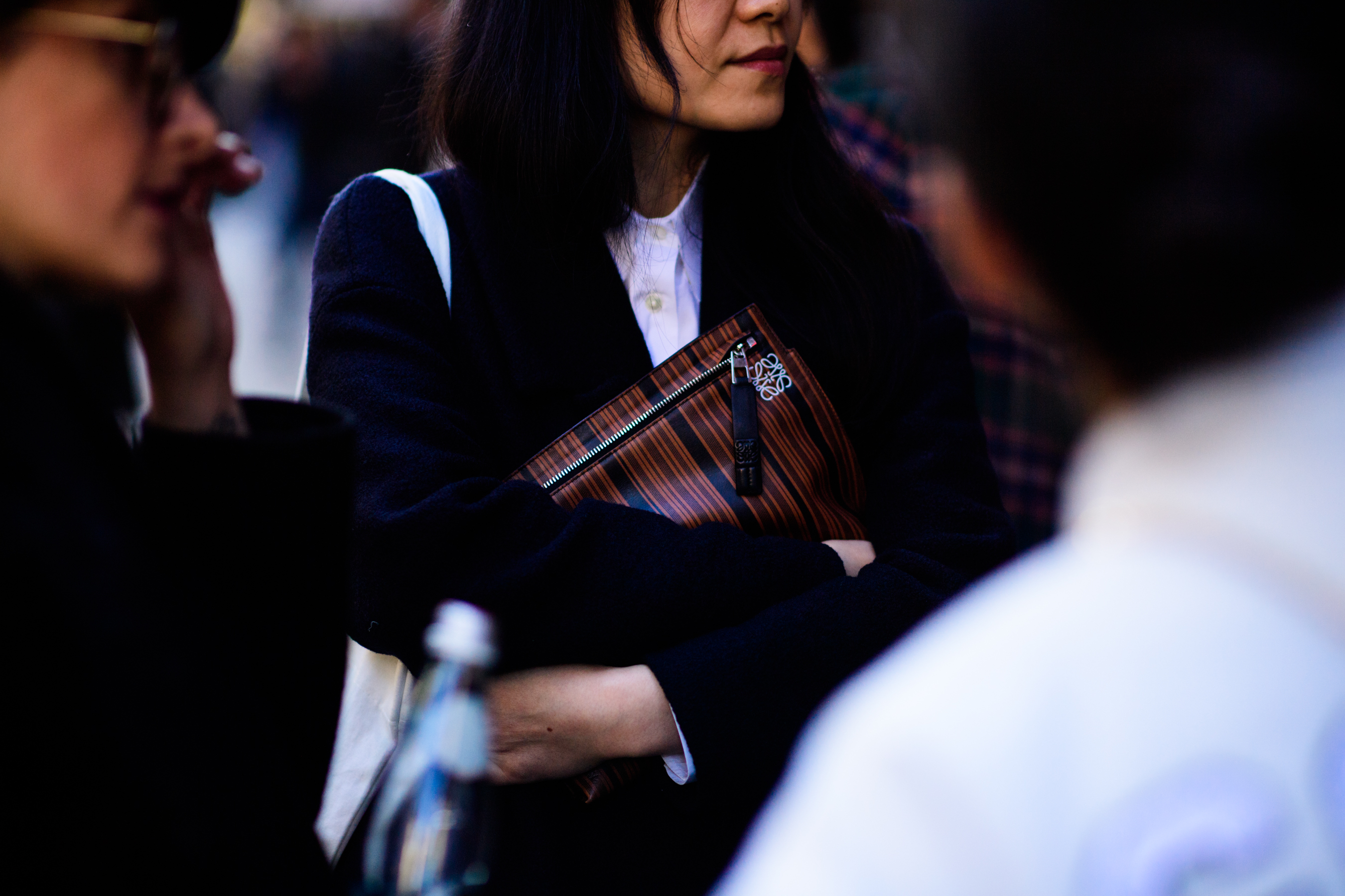 Woman holding Loewe clutch bag