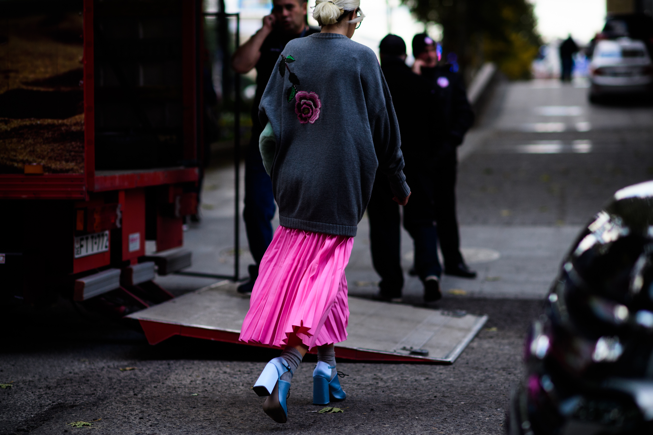 Woman wearing pink skirt and blue shoes