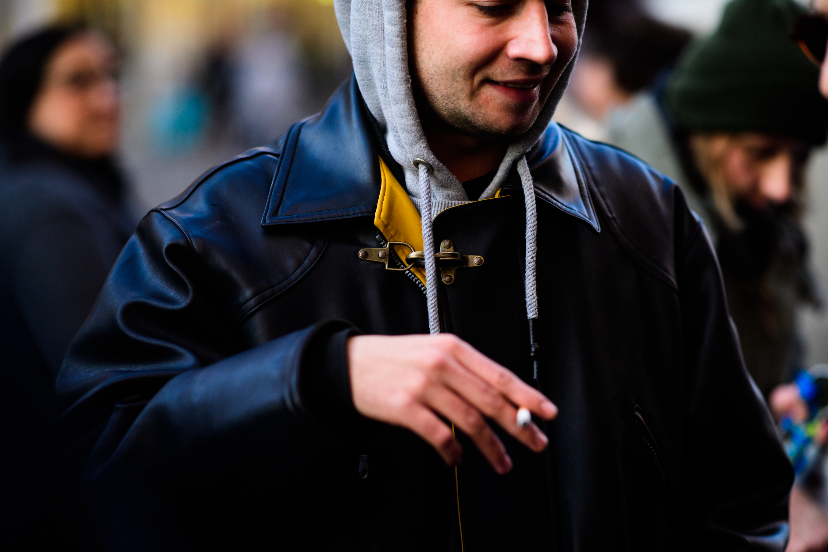 Man wearing grey hoodie under leather jacket