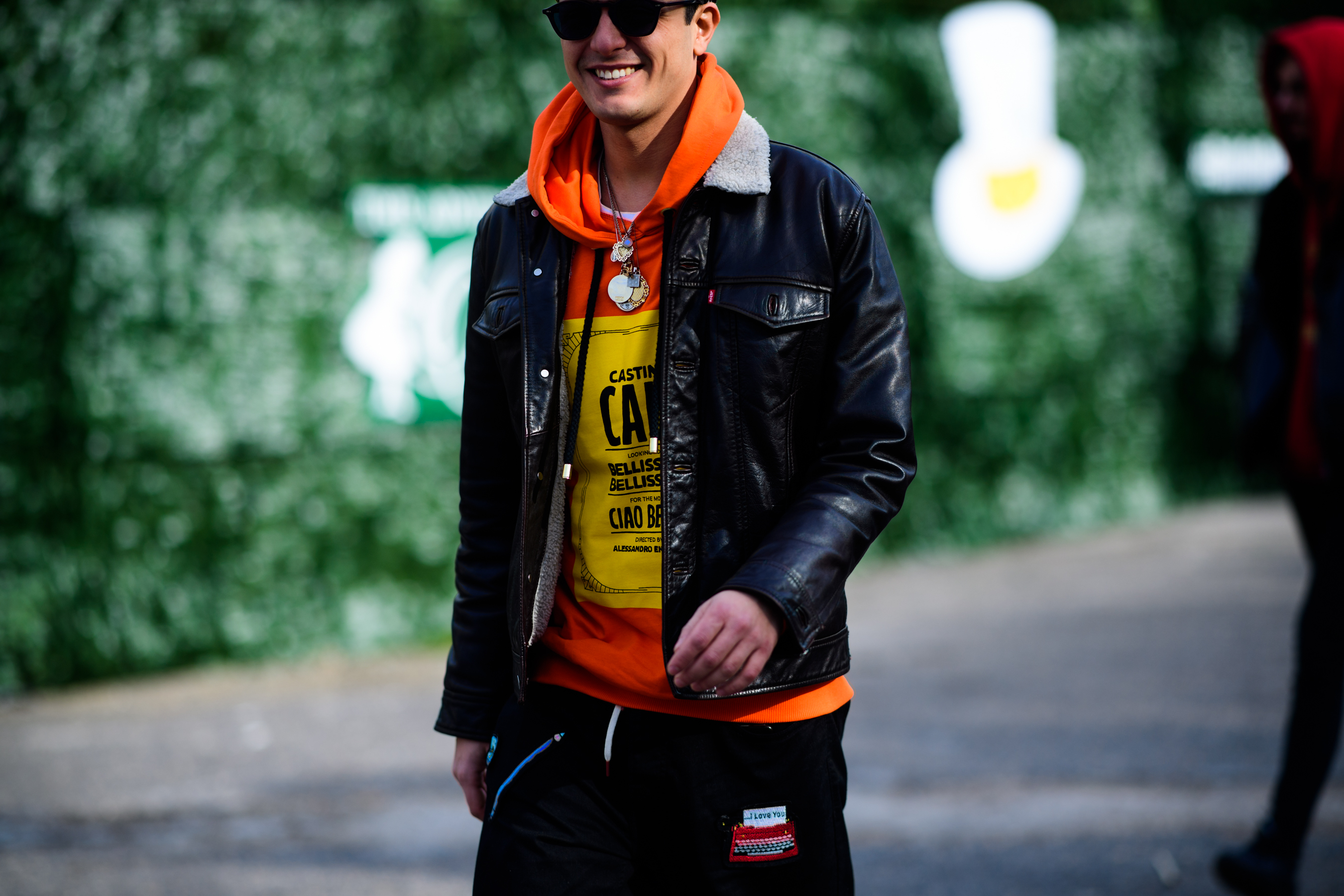 Man wearing orange hoodie under leather jacket