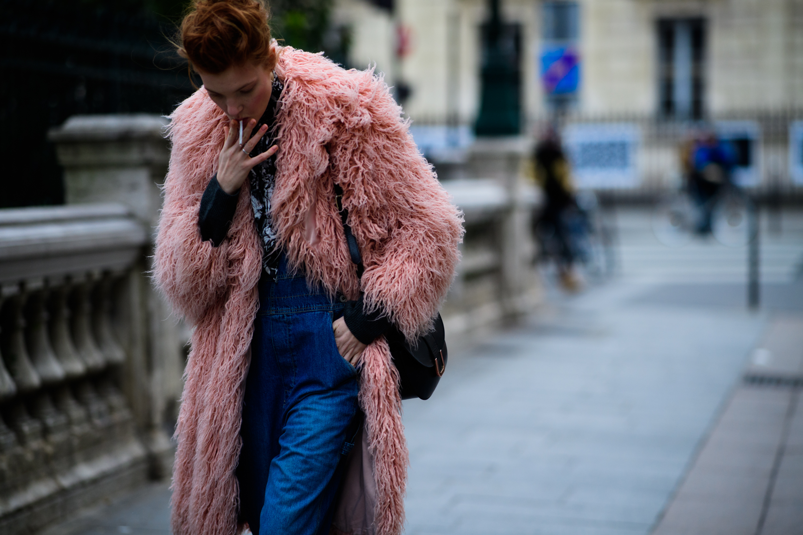 Woman wearing pink fur coat and denim pants