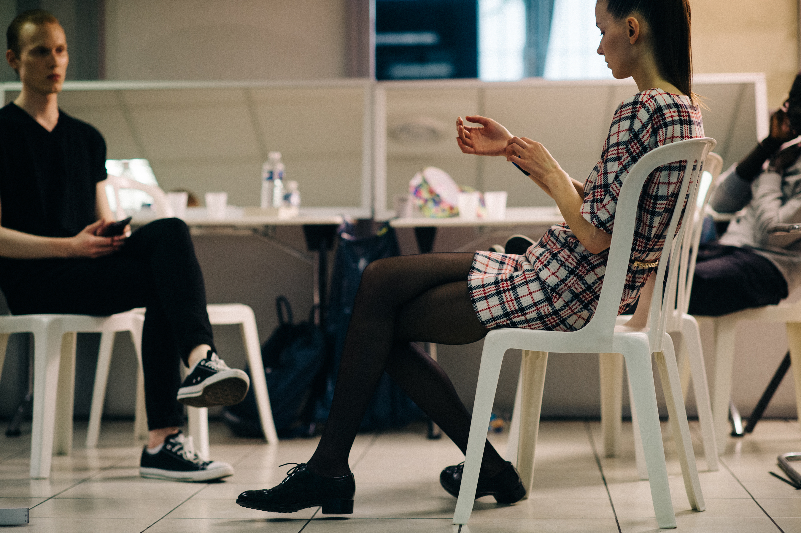 Model sitting on plastic chairs