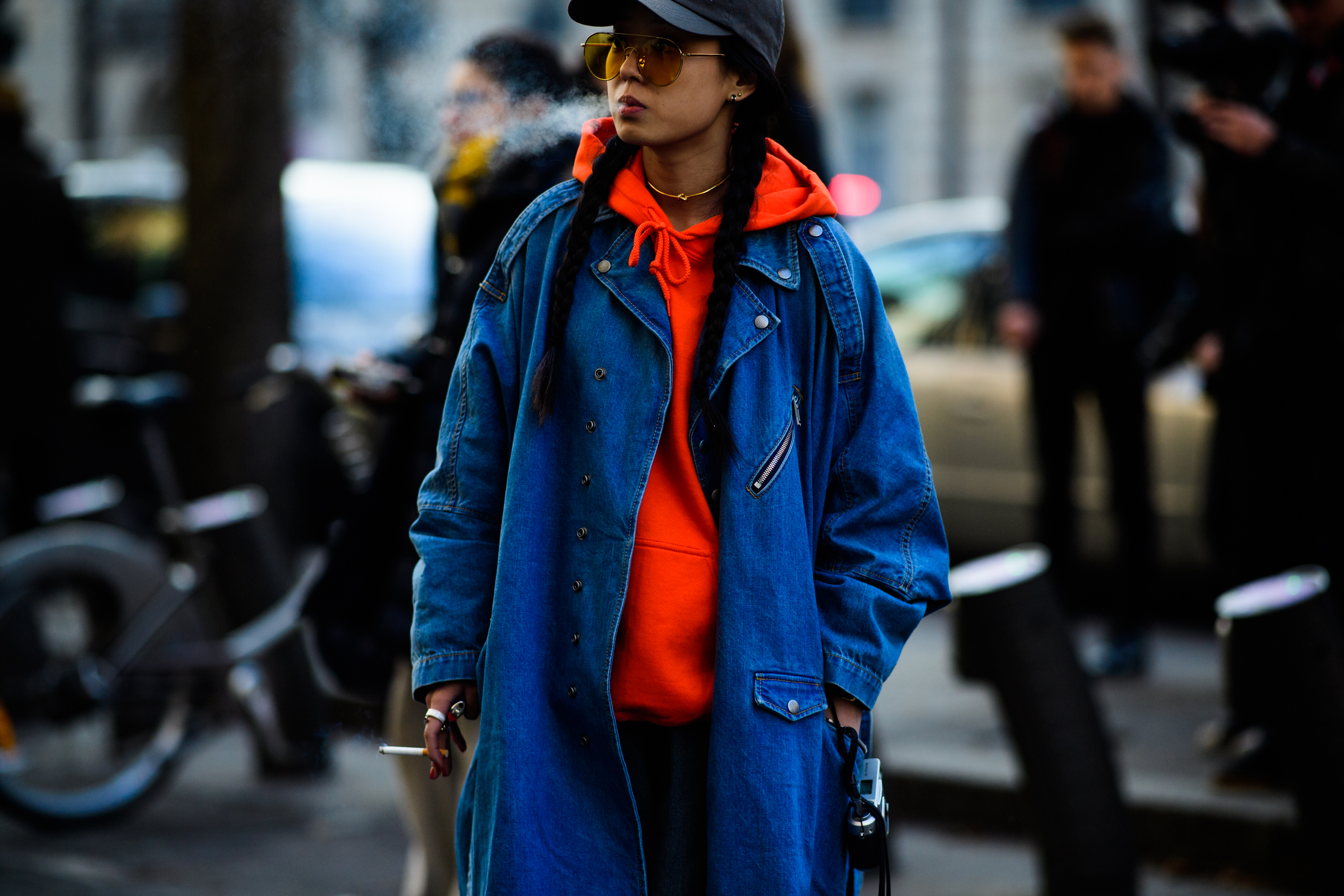 Woman wearing orange hoodie under denim coat