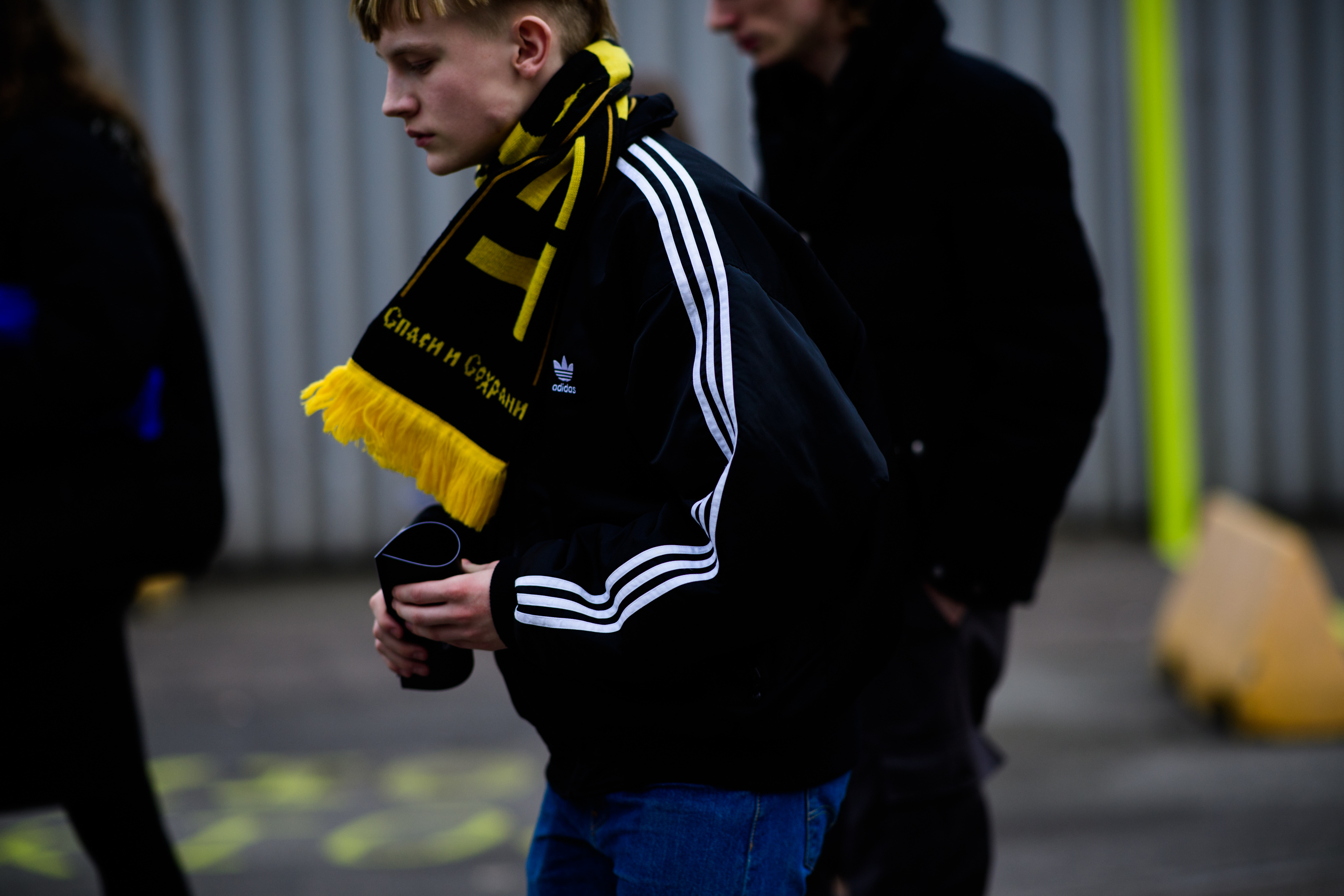 Man wearing Adidas jacket and Gosha scarf