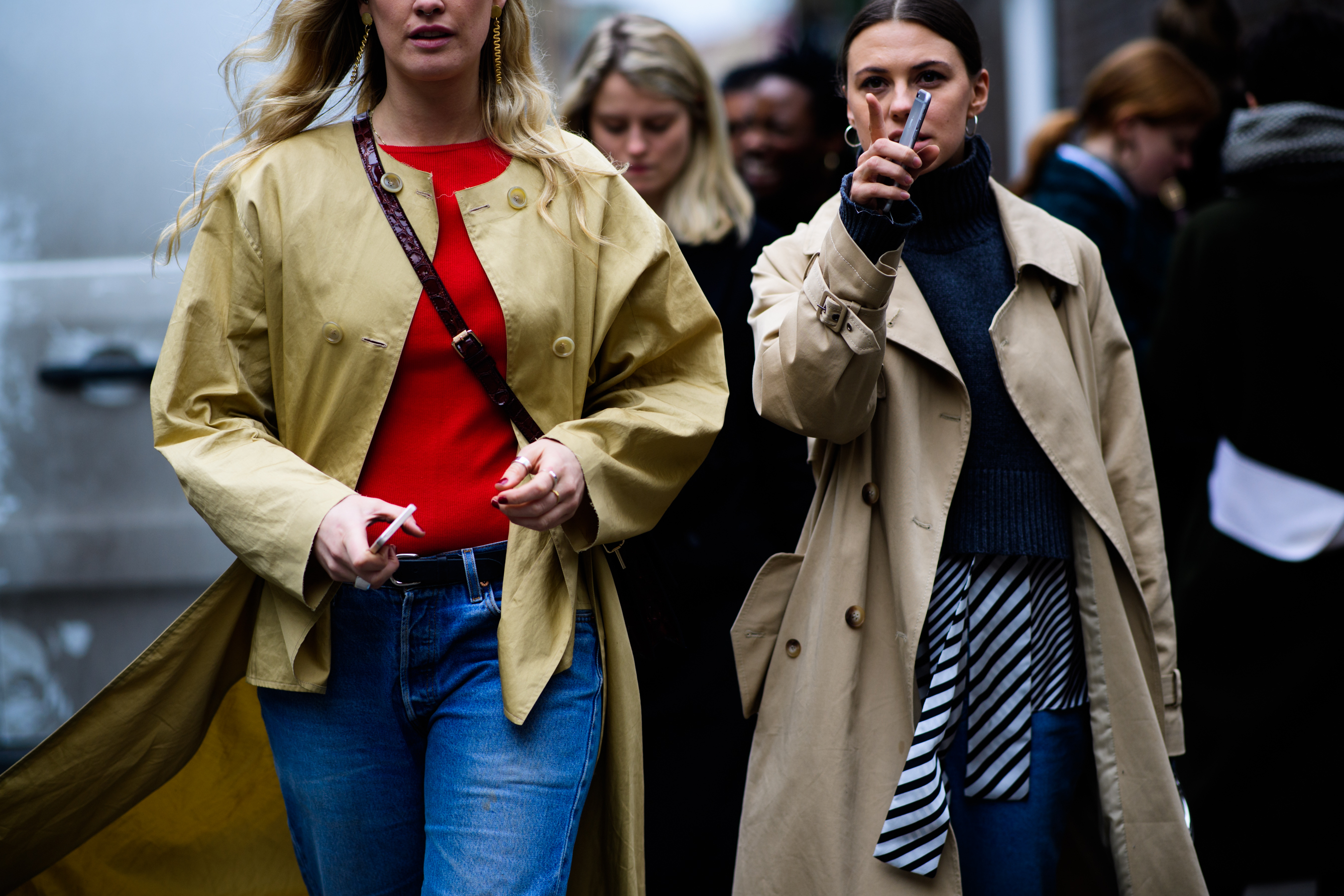 Two women wearing beige trenches
