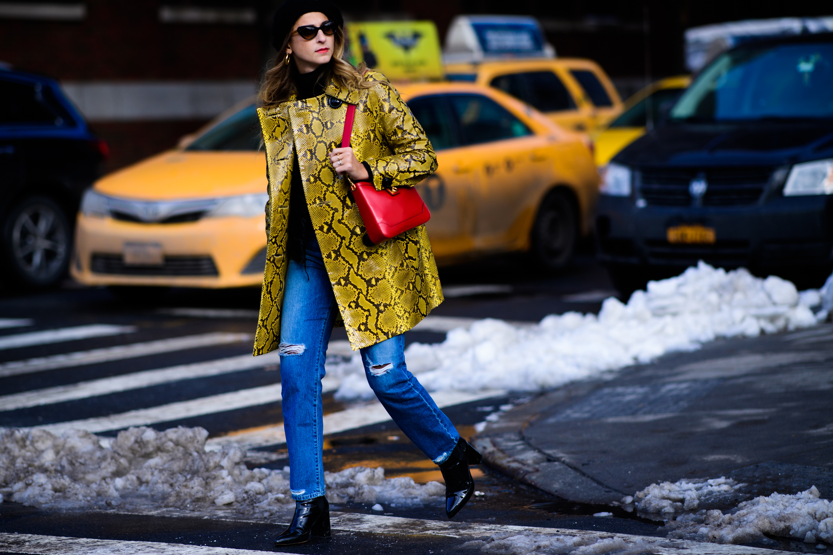 Woman wearing red handbag and blue jeans