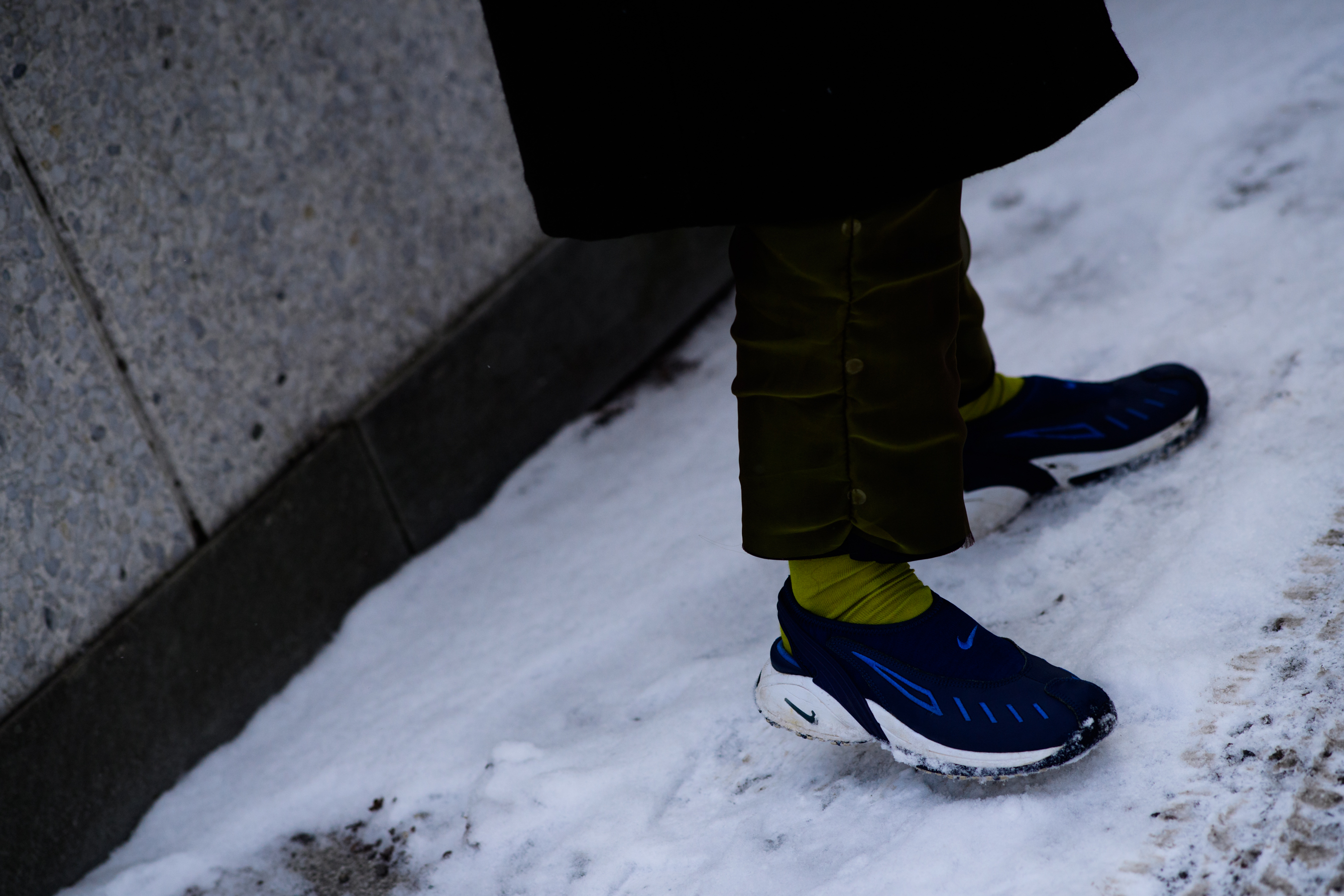 Man wearing green socks and blue shoes
