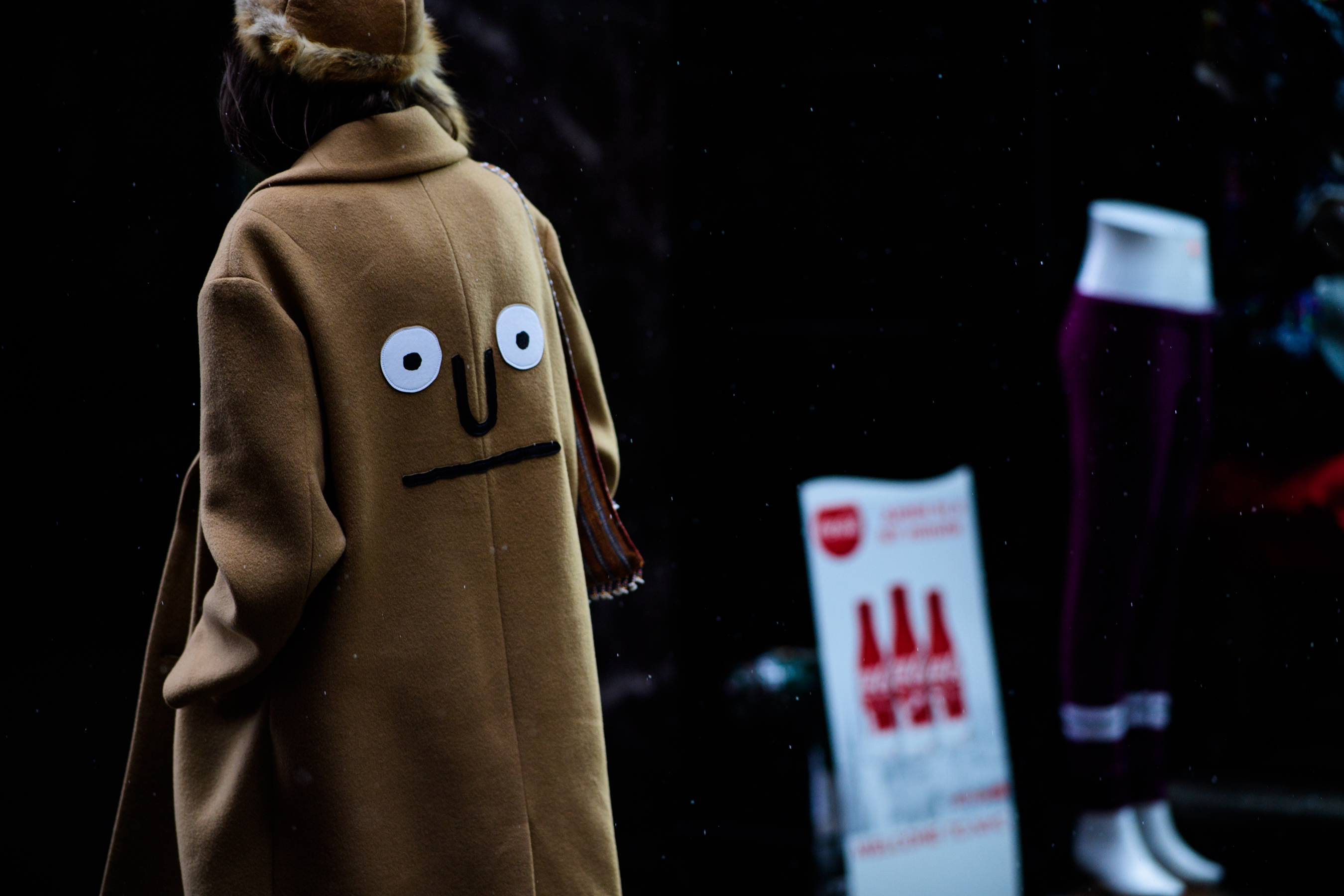 Woman wearing beige coat with face