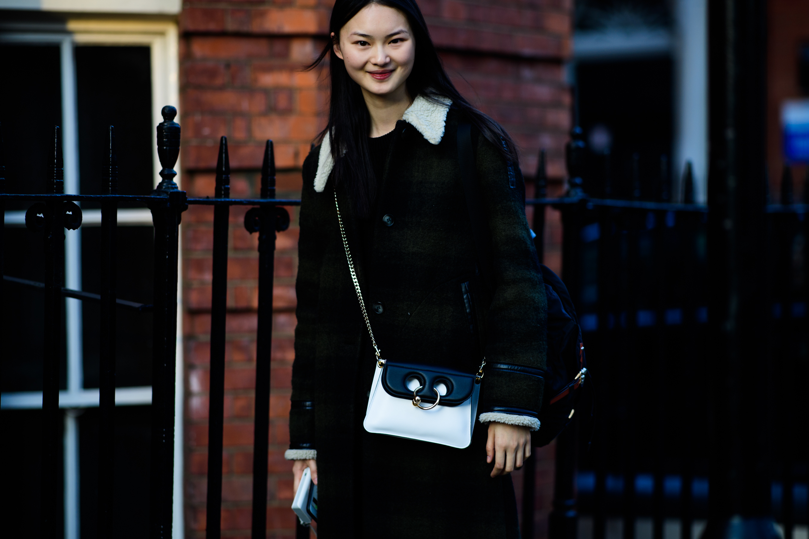 Model wearing black clothes and white J.W. bag