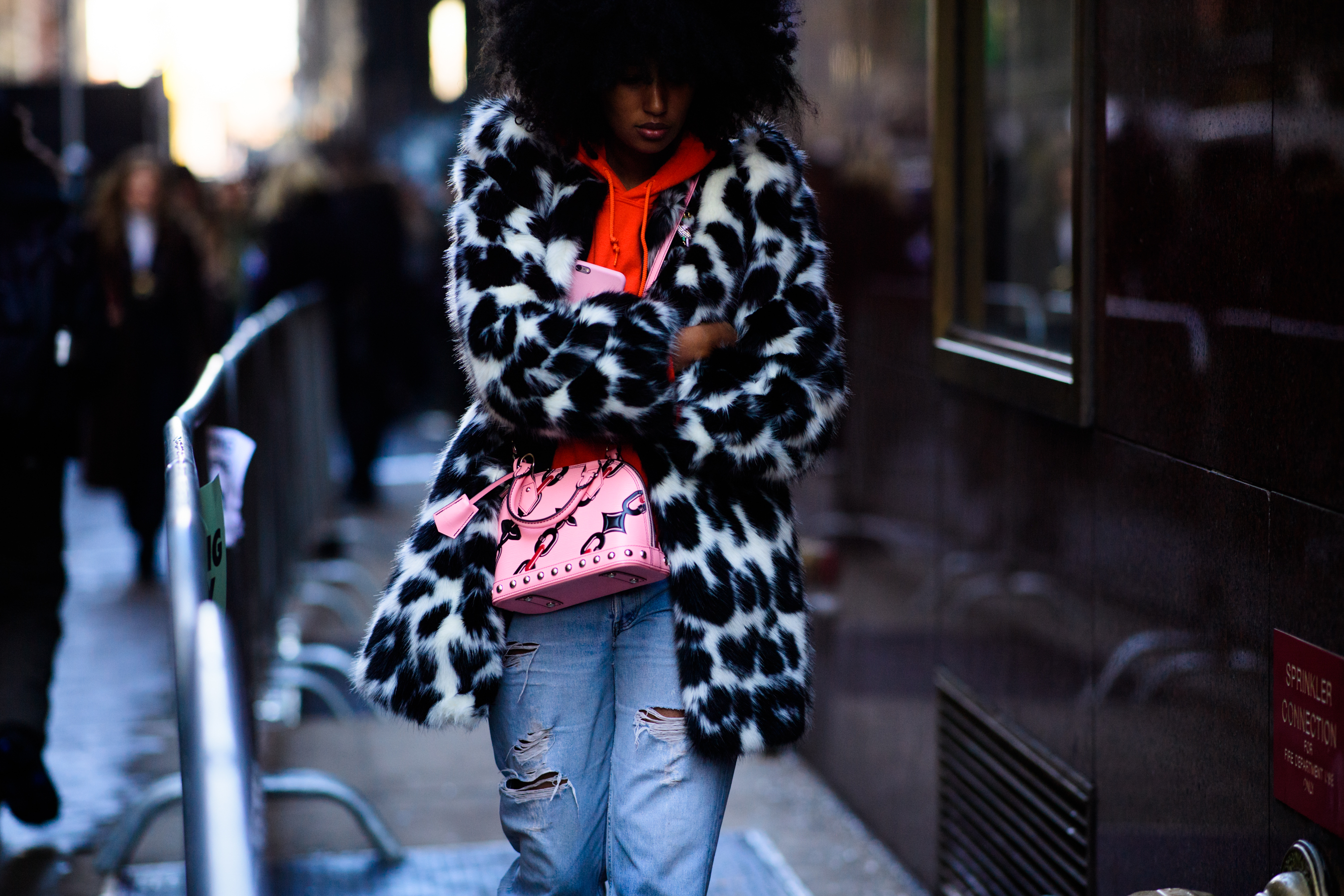 Woman wearing fur coat and LV handbag