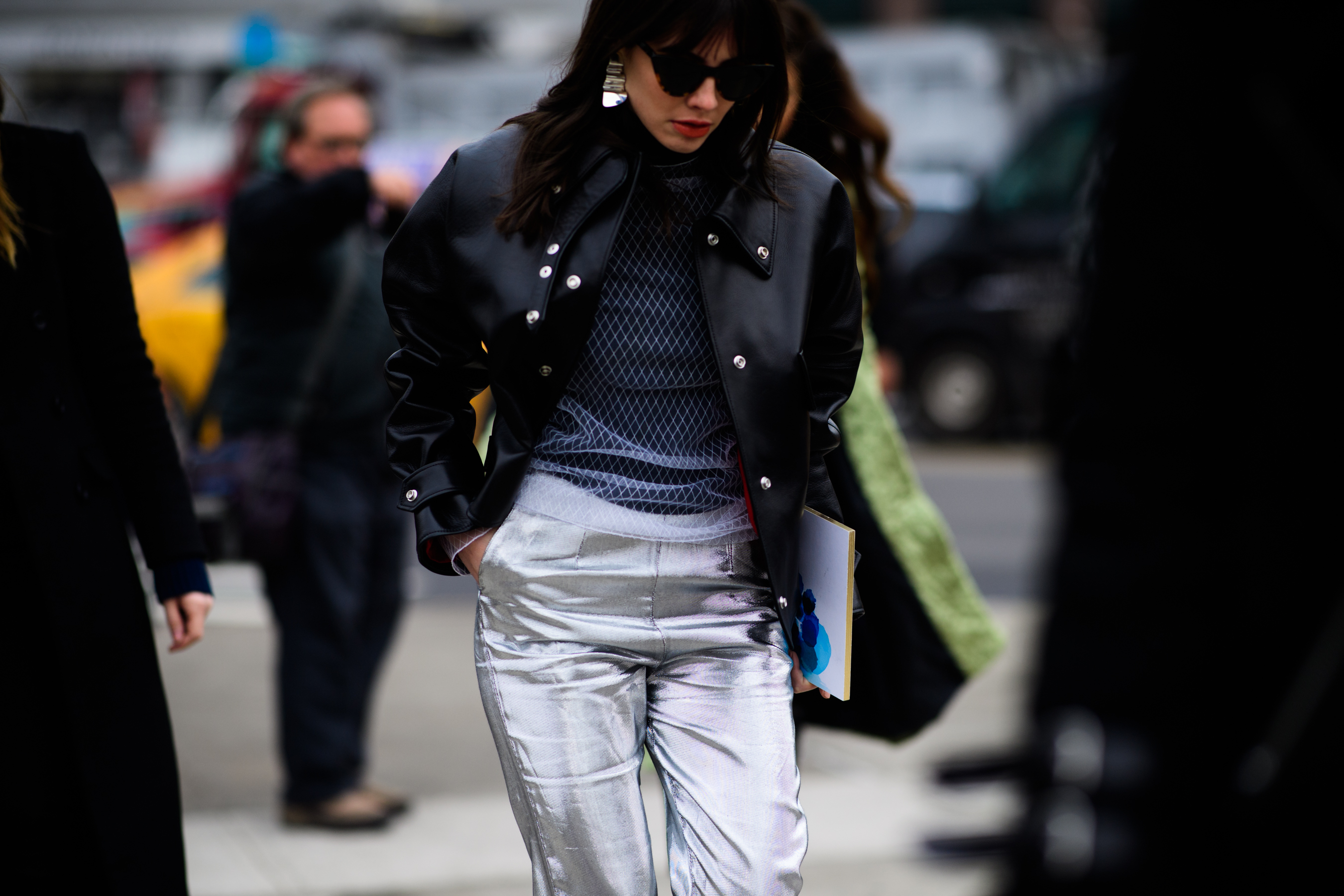 Woman wearing white pants and black jacket