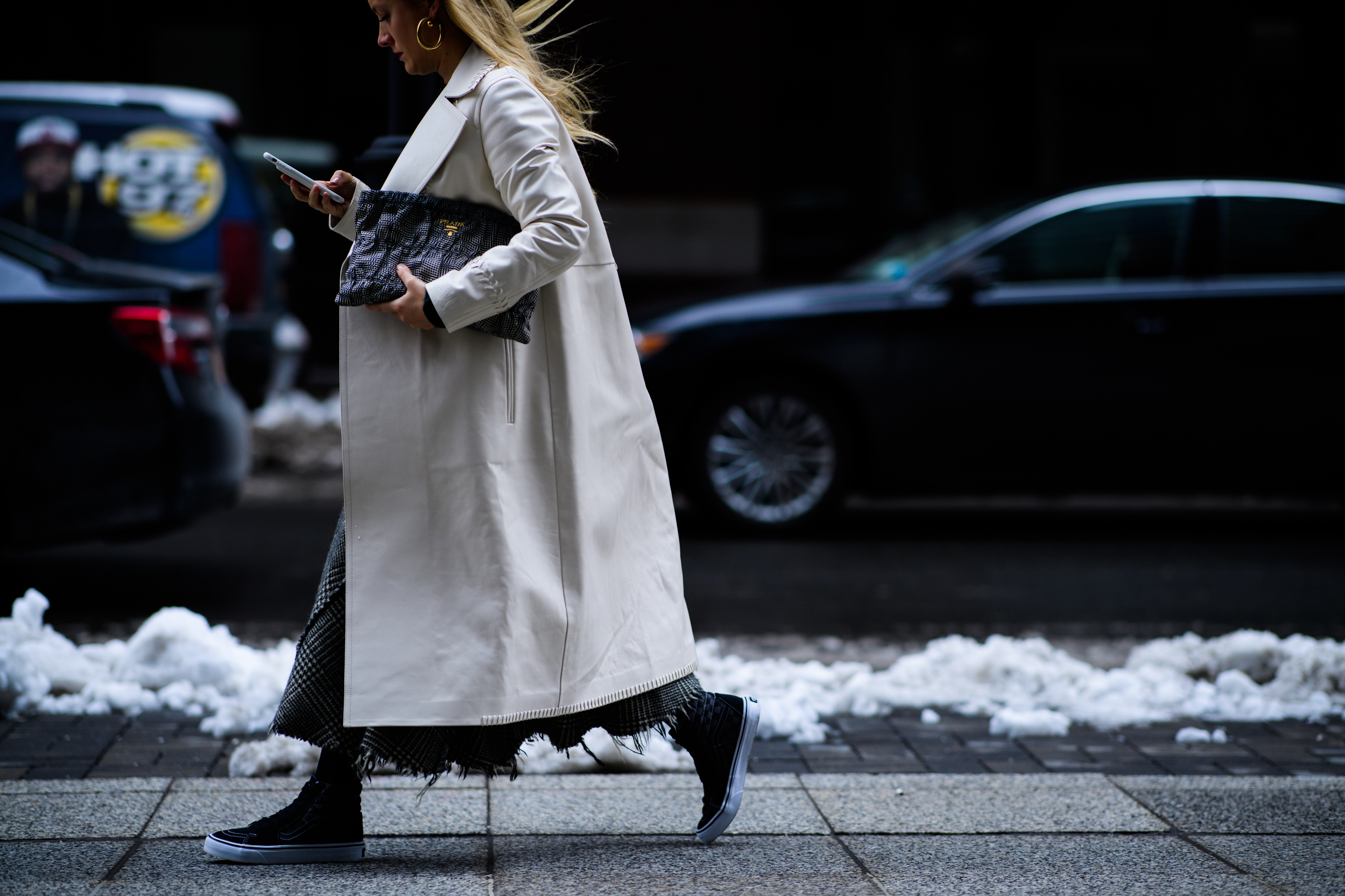 Woman wearing Prada bag and Vans shoes