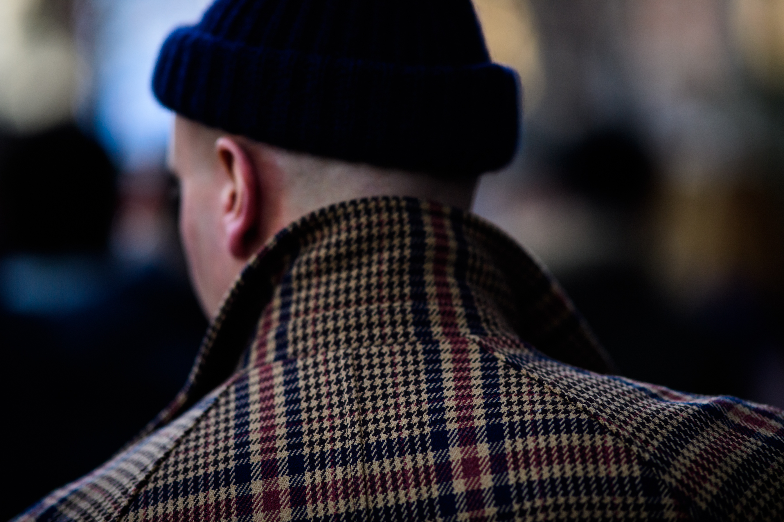 Man wearing black hat and checkered jacket