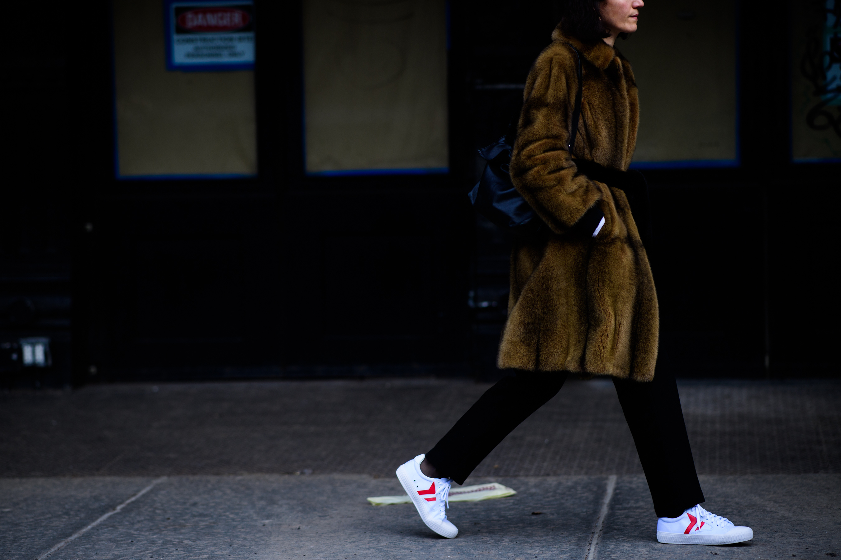 Woman wearing fur coat with sneakers