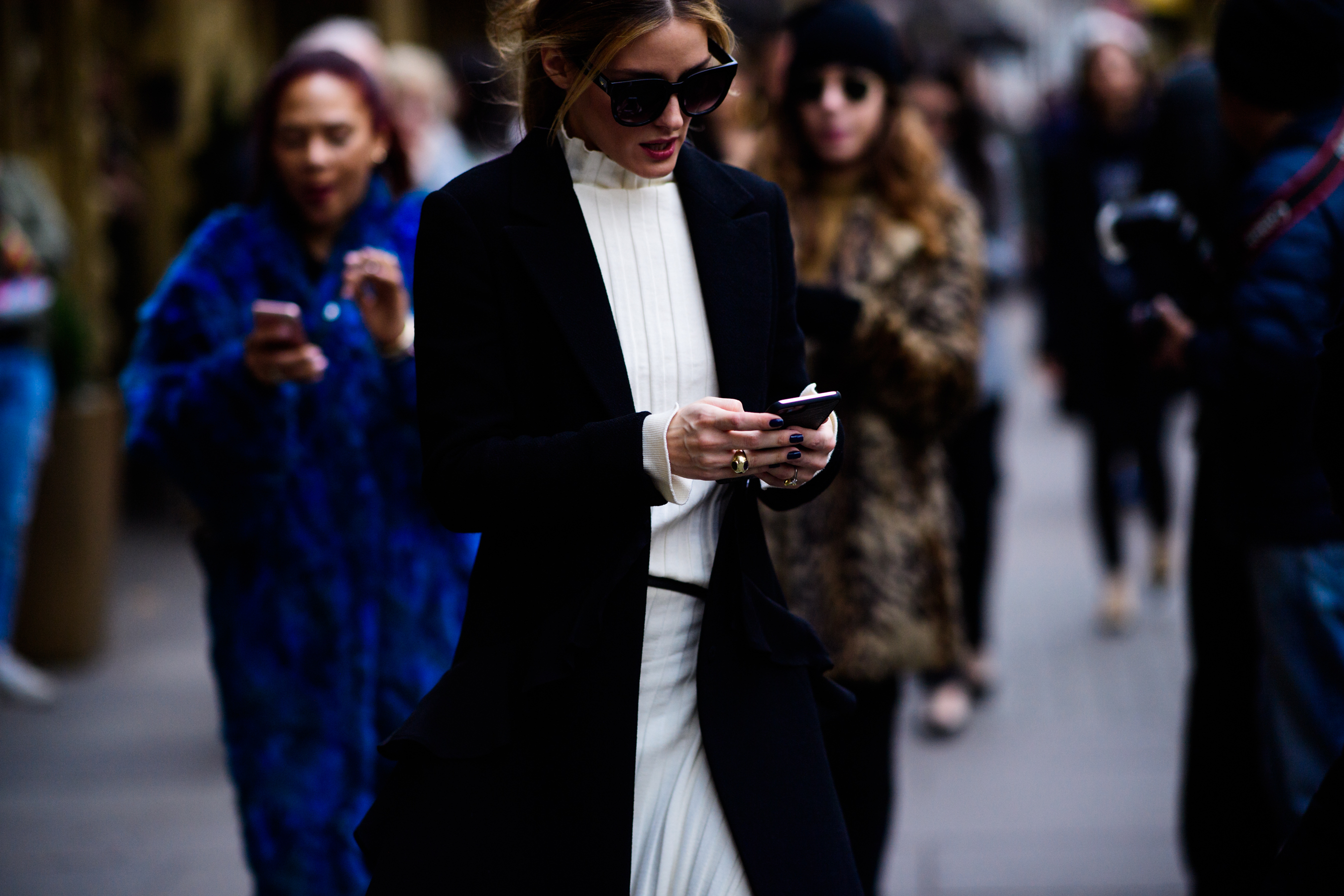 American model wearing sunglasses and black coat