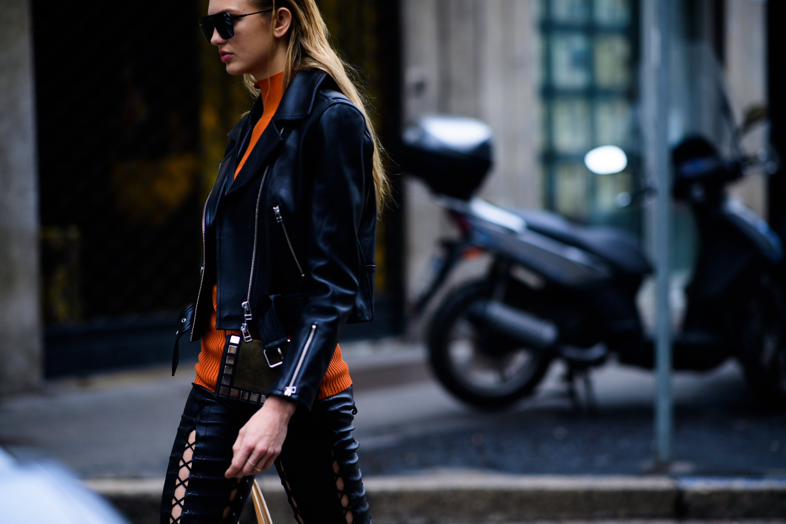 Model wearing orange sweater and leather jacket