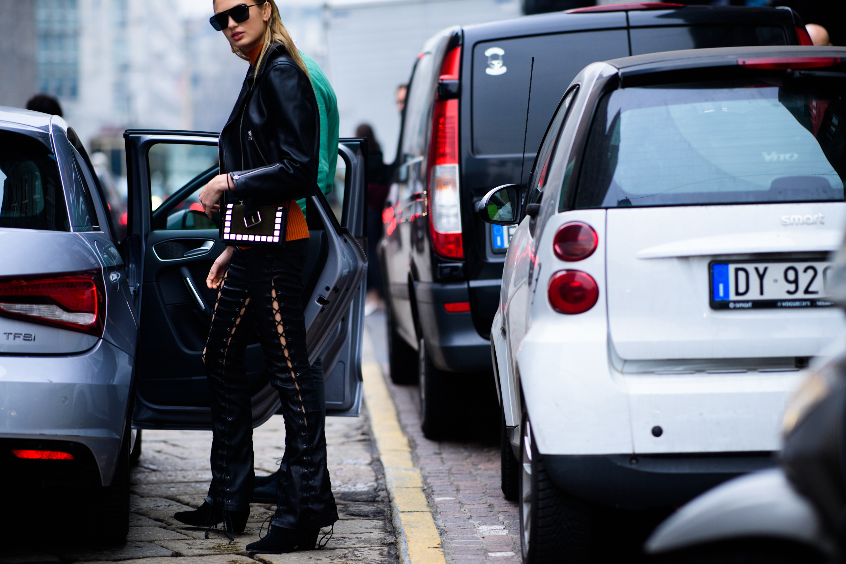 Model wearing orange sweater and leather jacket