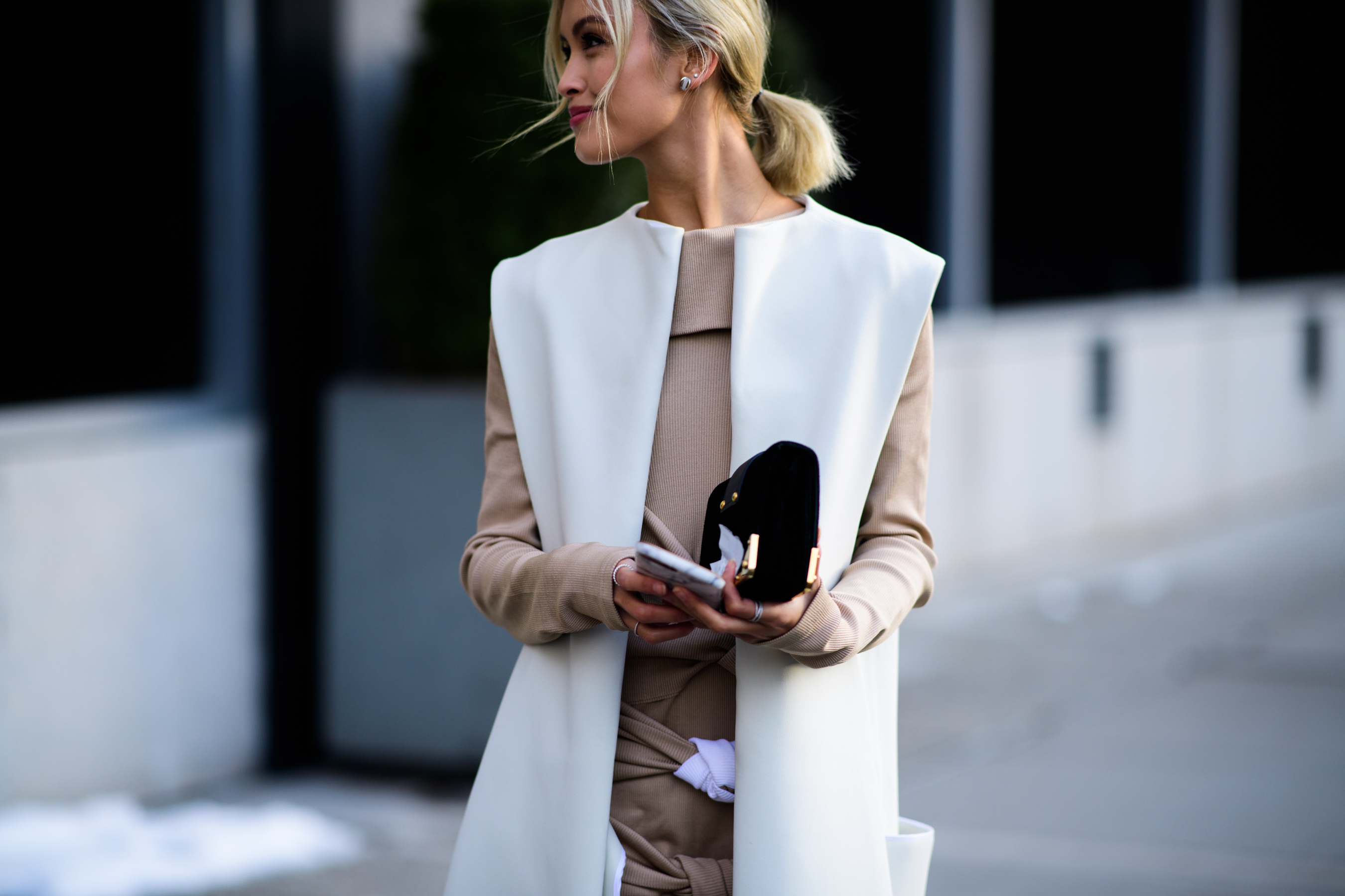 Woman wearing white big jacket without sleeves