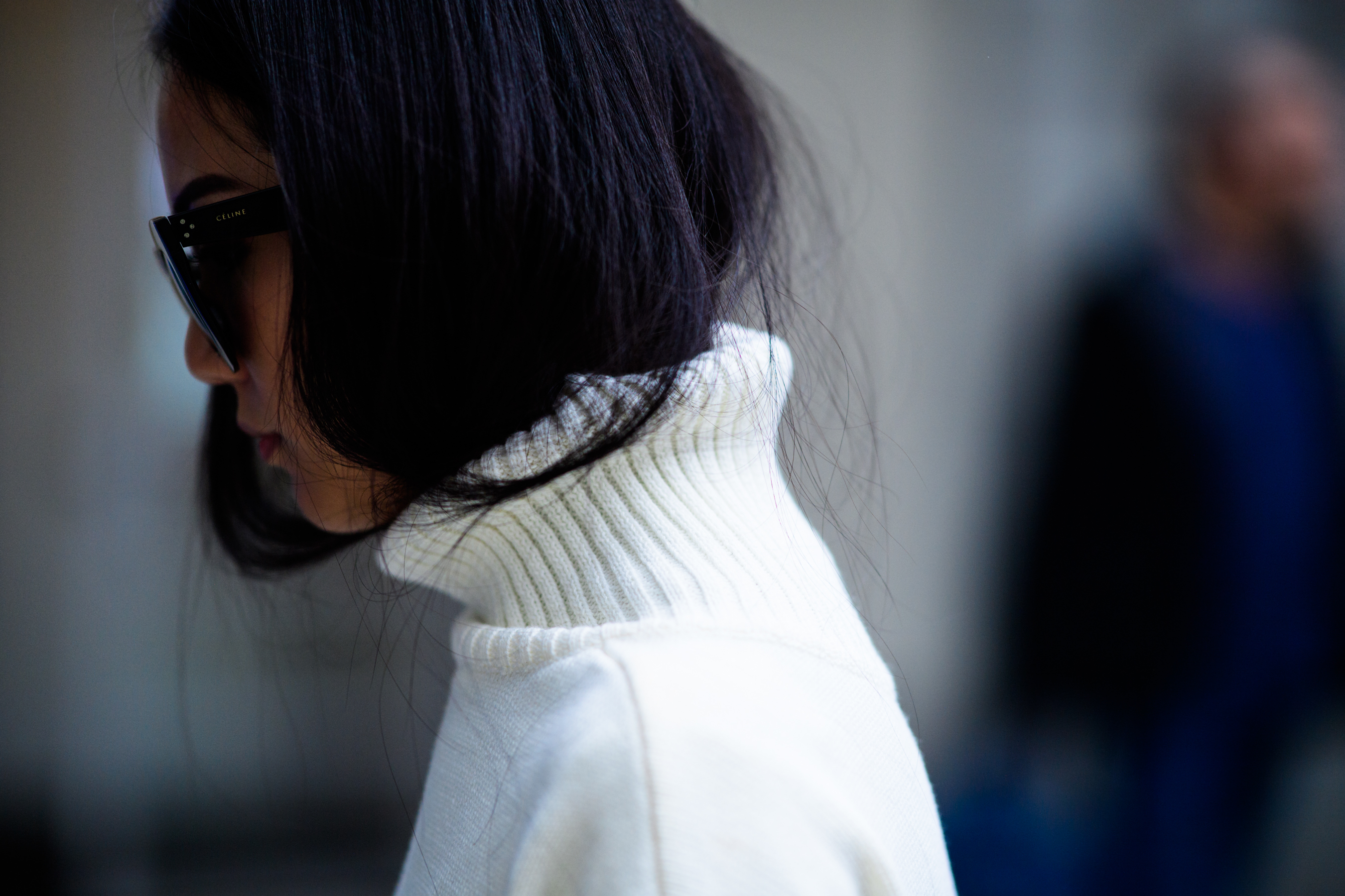 Woman wearing white sweater with big collar