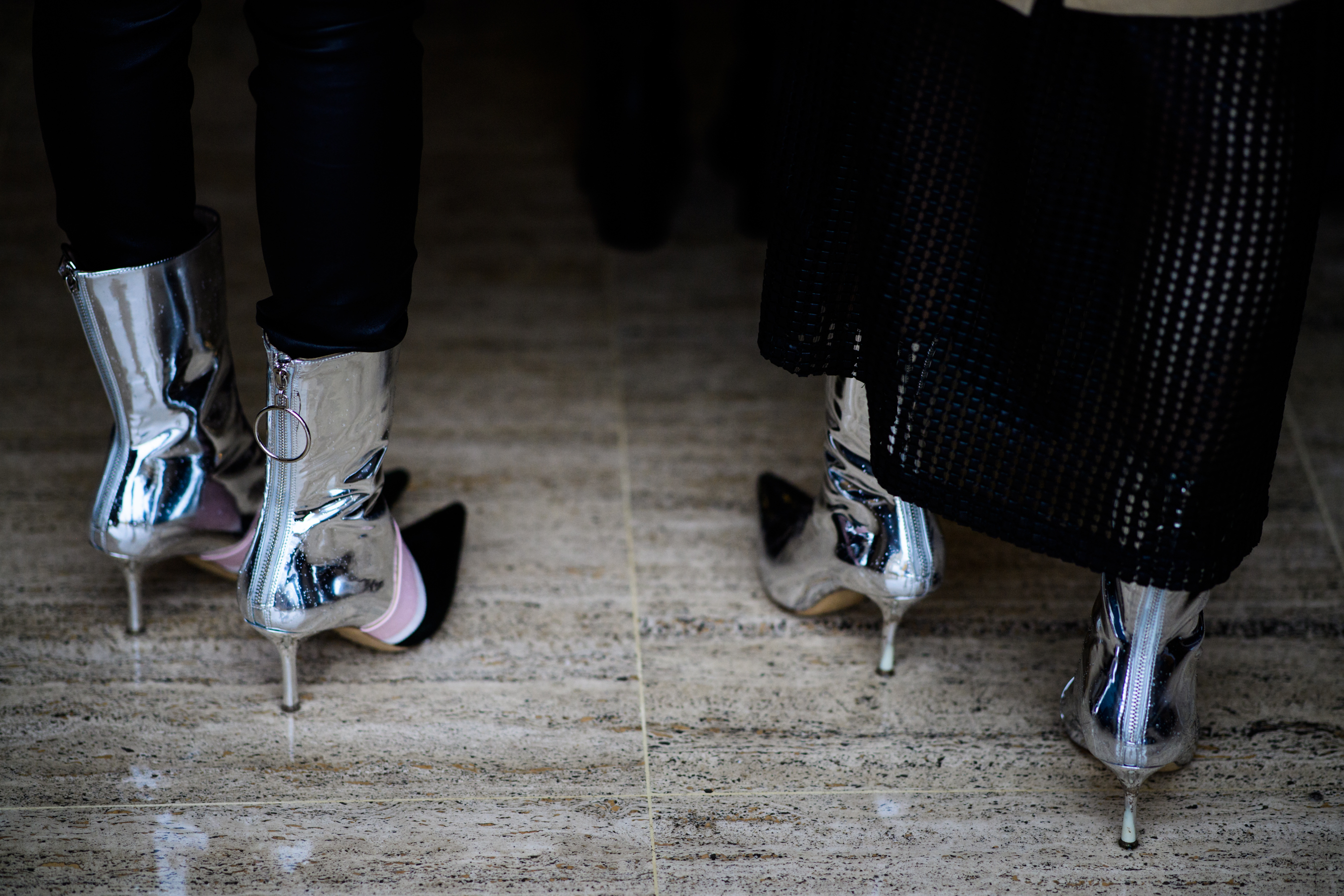 Two women wearing silver boots