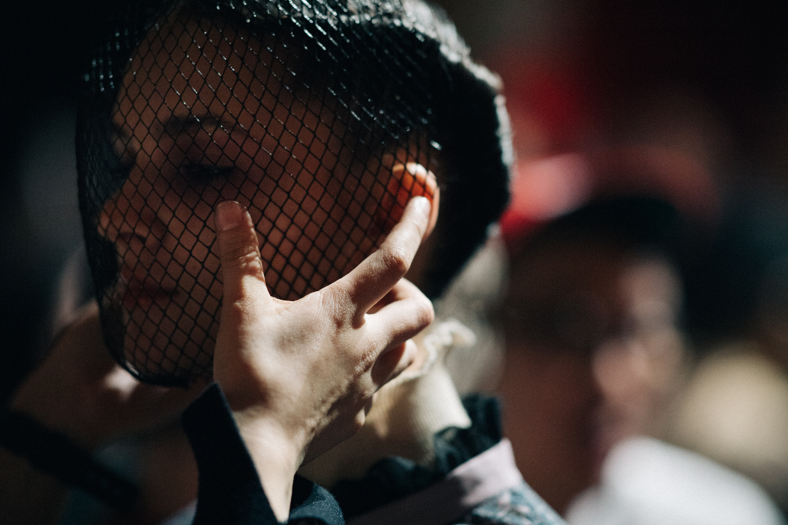 Model getting fencing mask put on