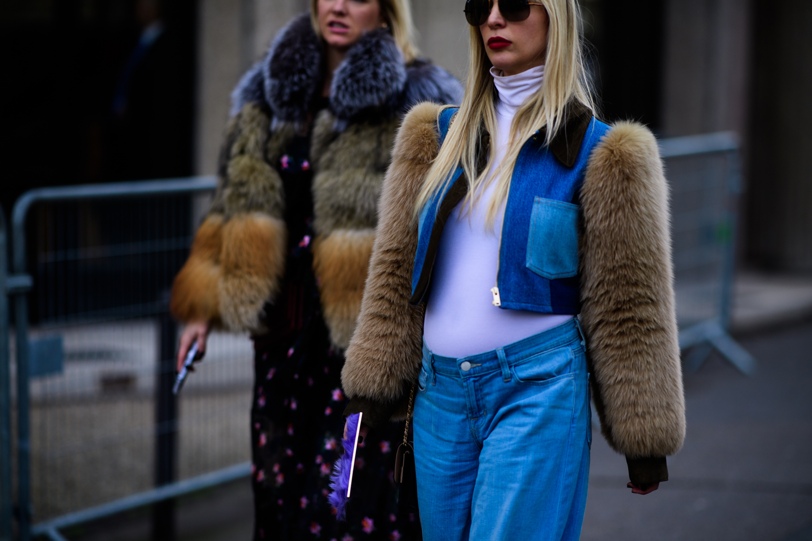 Two women wearing fur coats