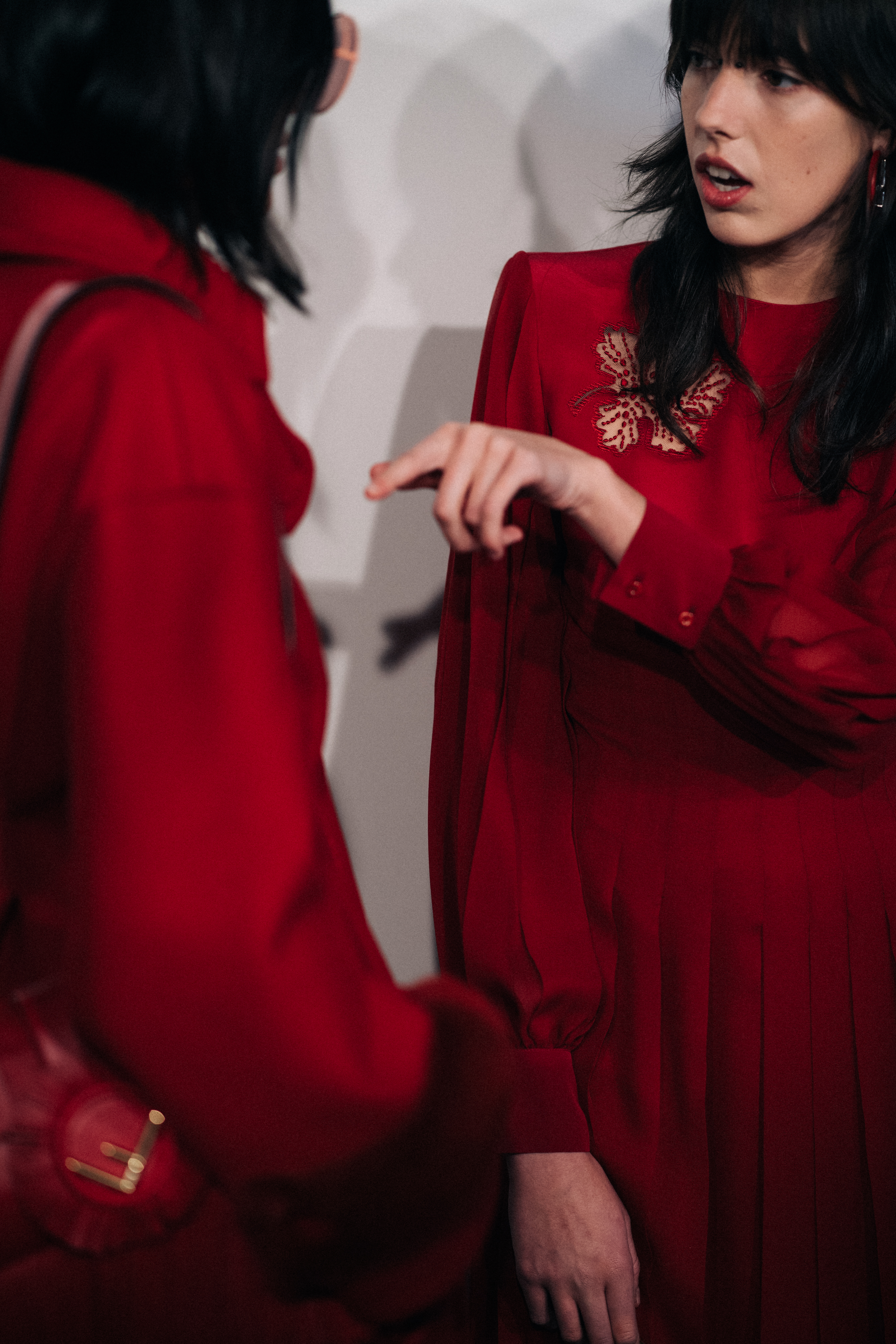 Two models wearing red before a show