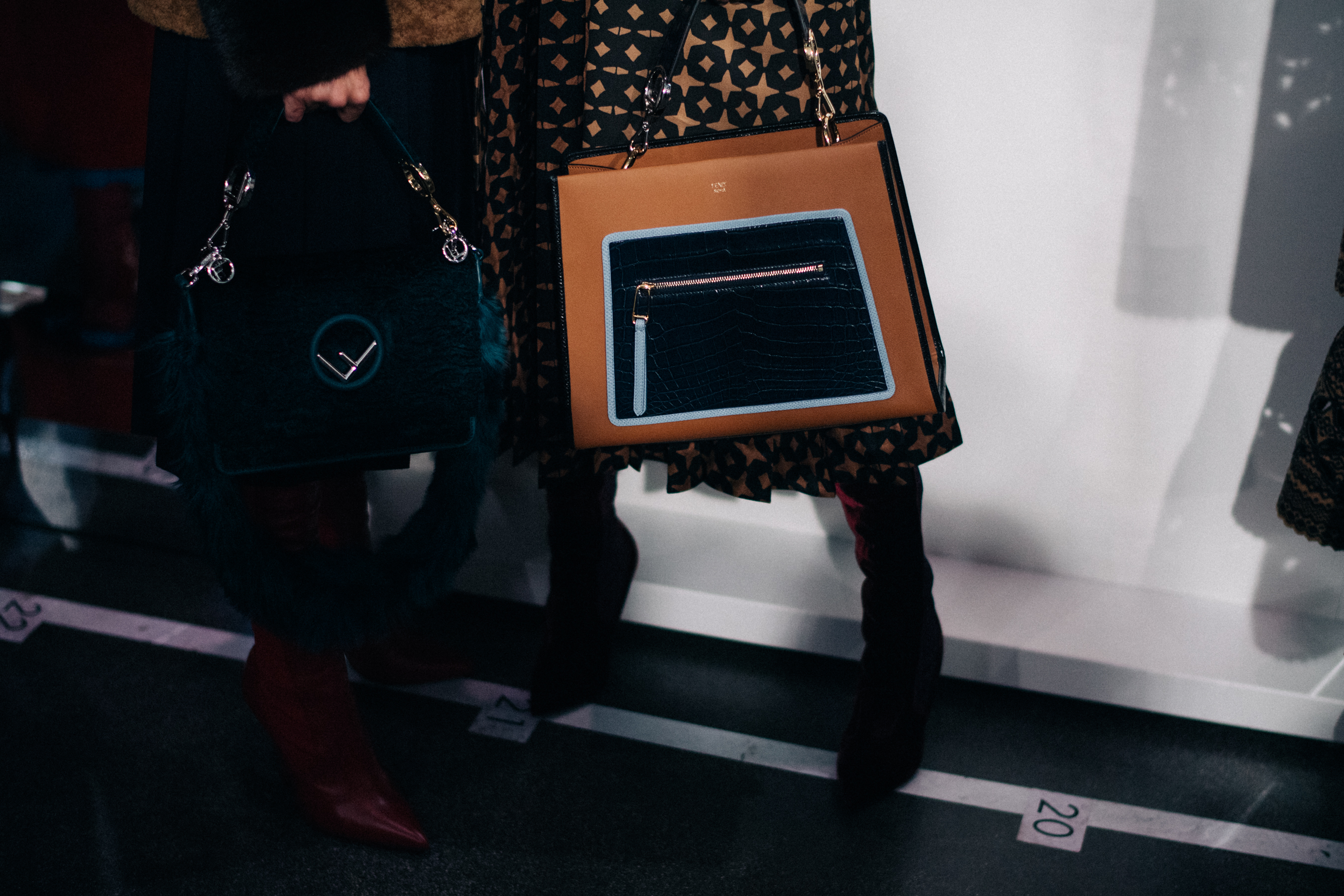 Two models holding hand bags