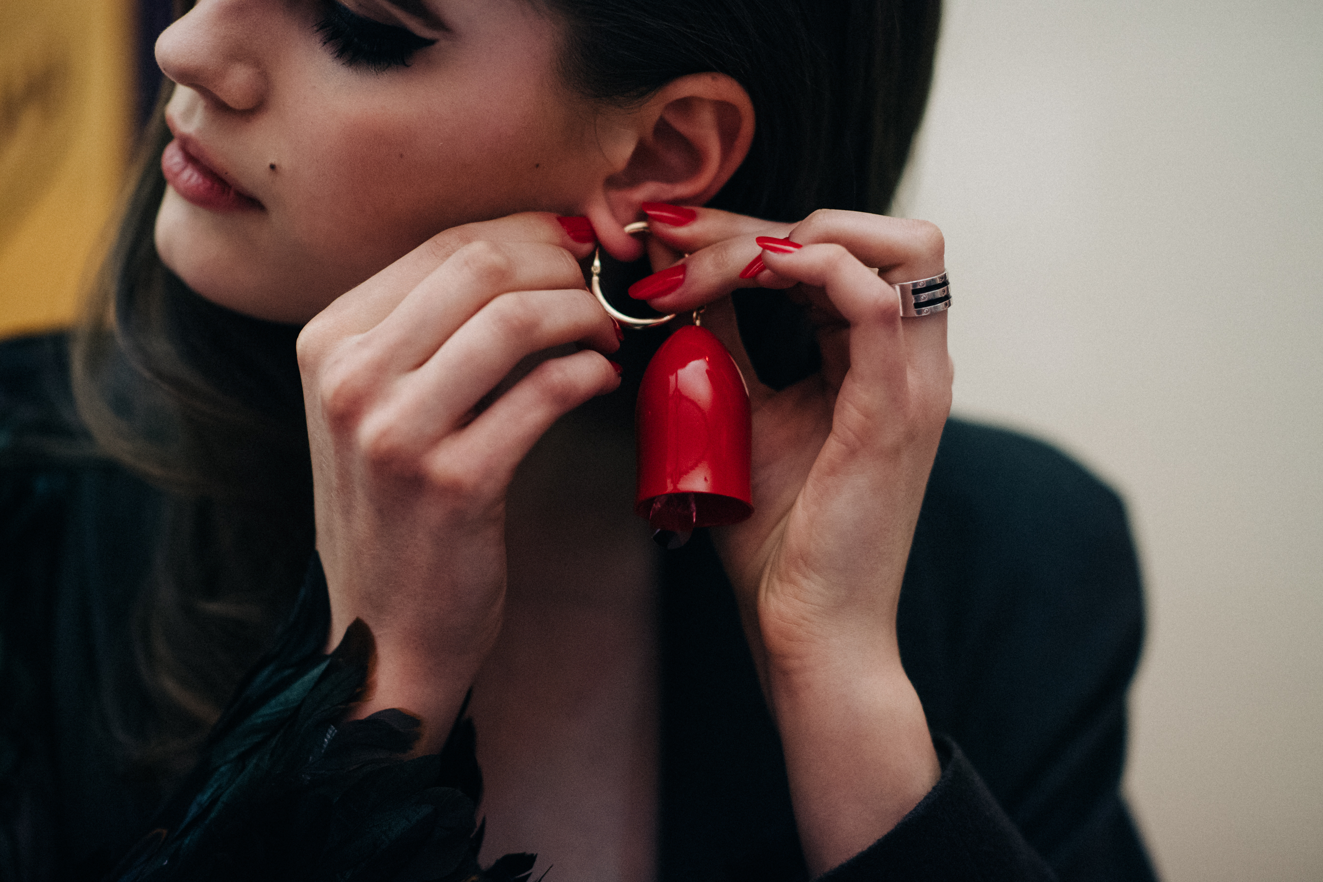 Model putting on red earring