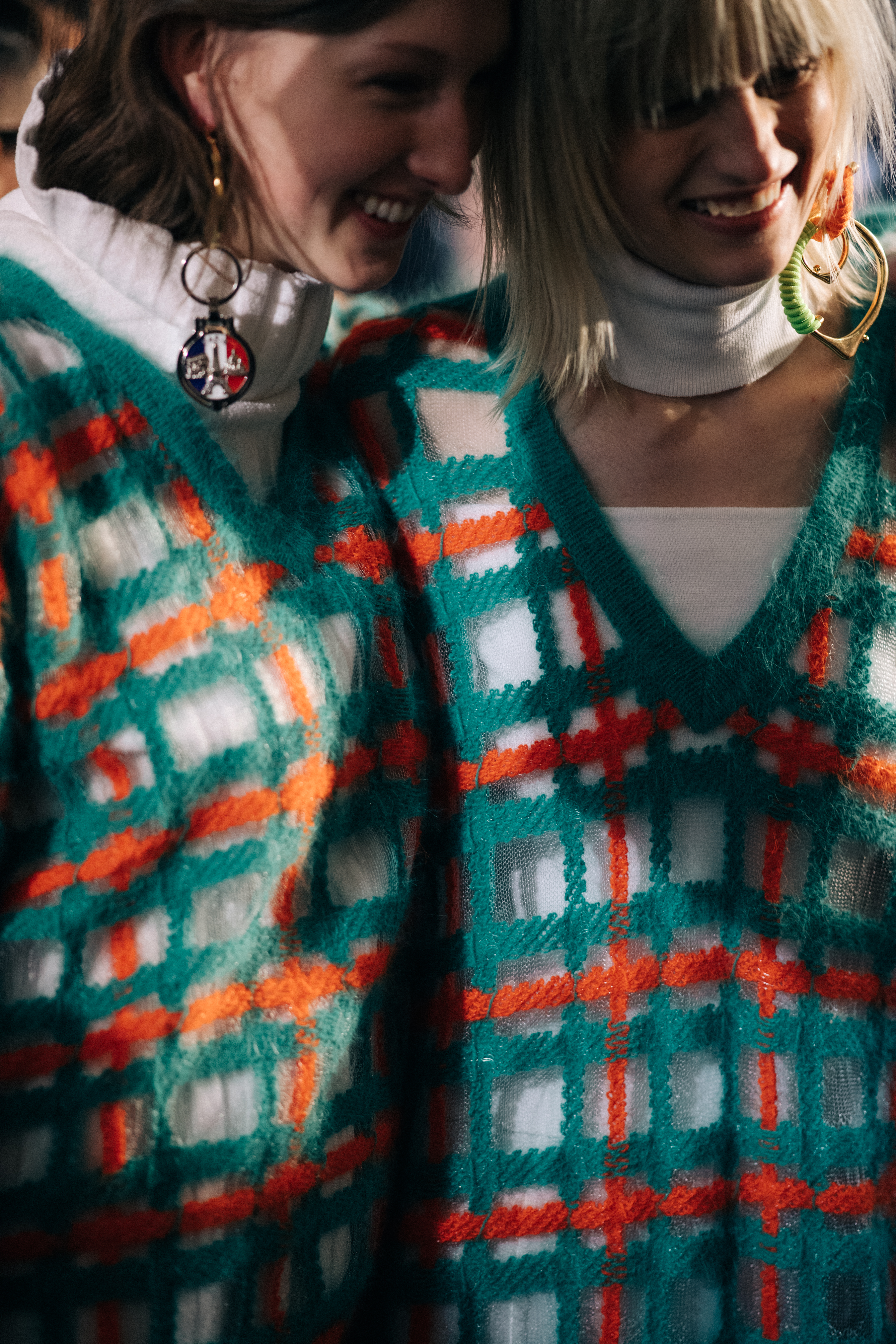 Two models wearing knitted tops