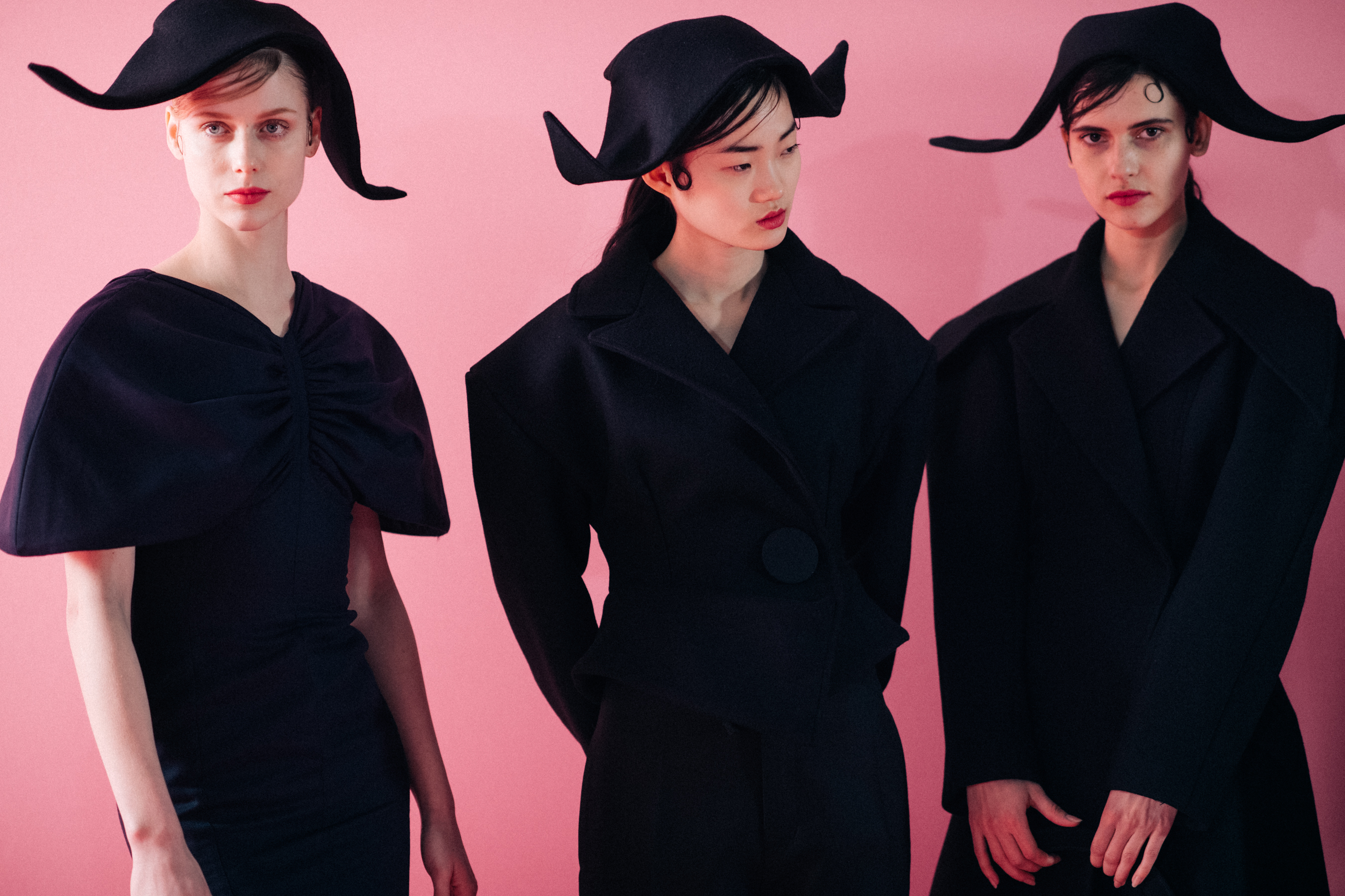 Three women wearing black hats