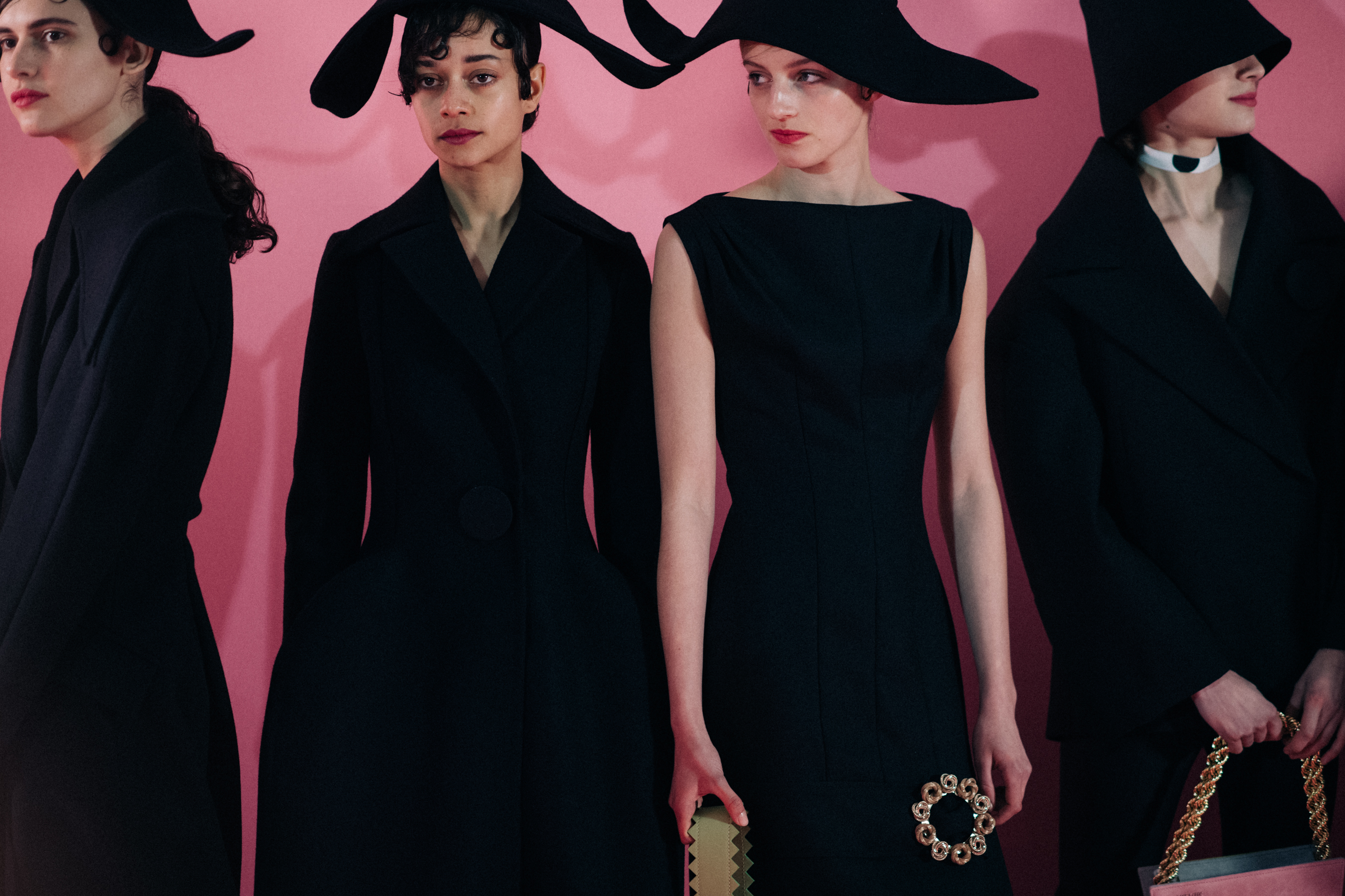 Four women wearing black outfits