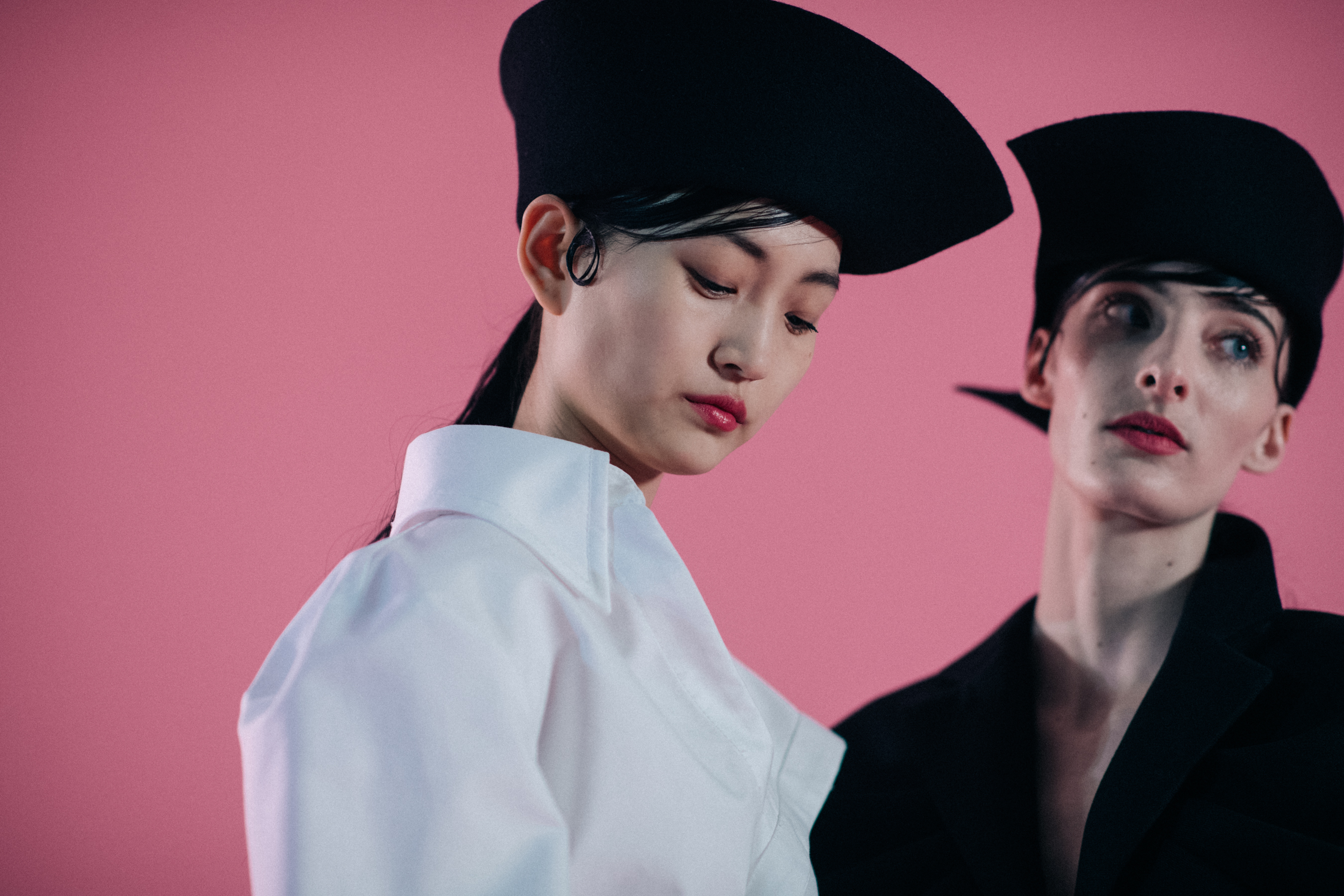Two girls wearing asymmetric hats