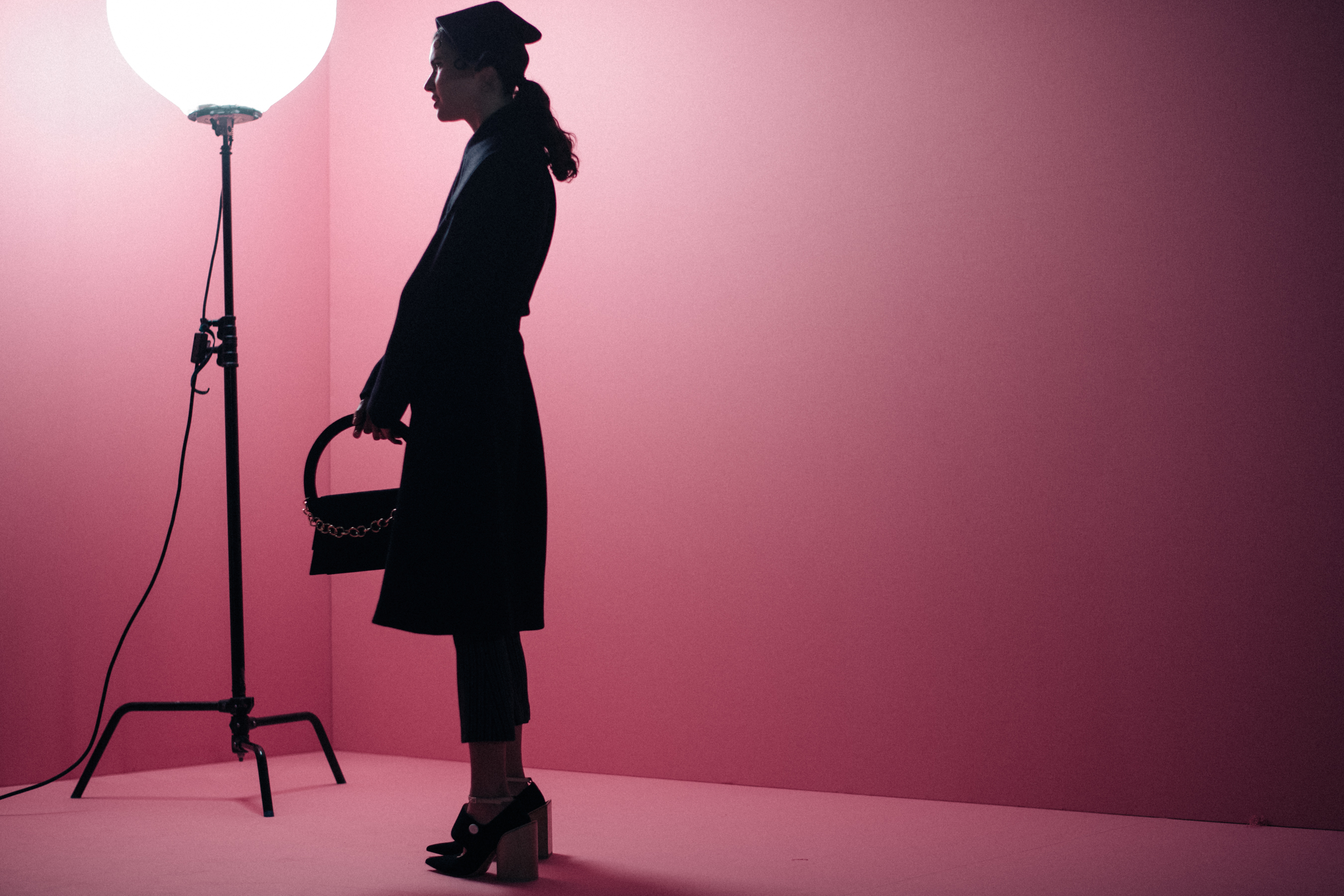 Girl staying agains a pink wall