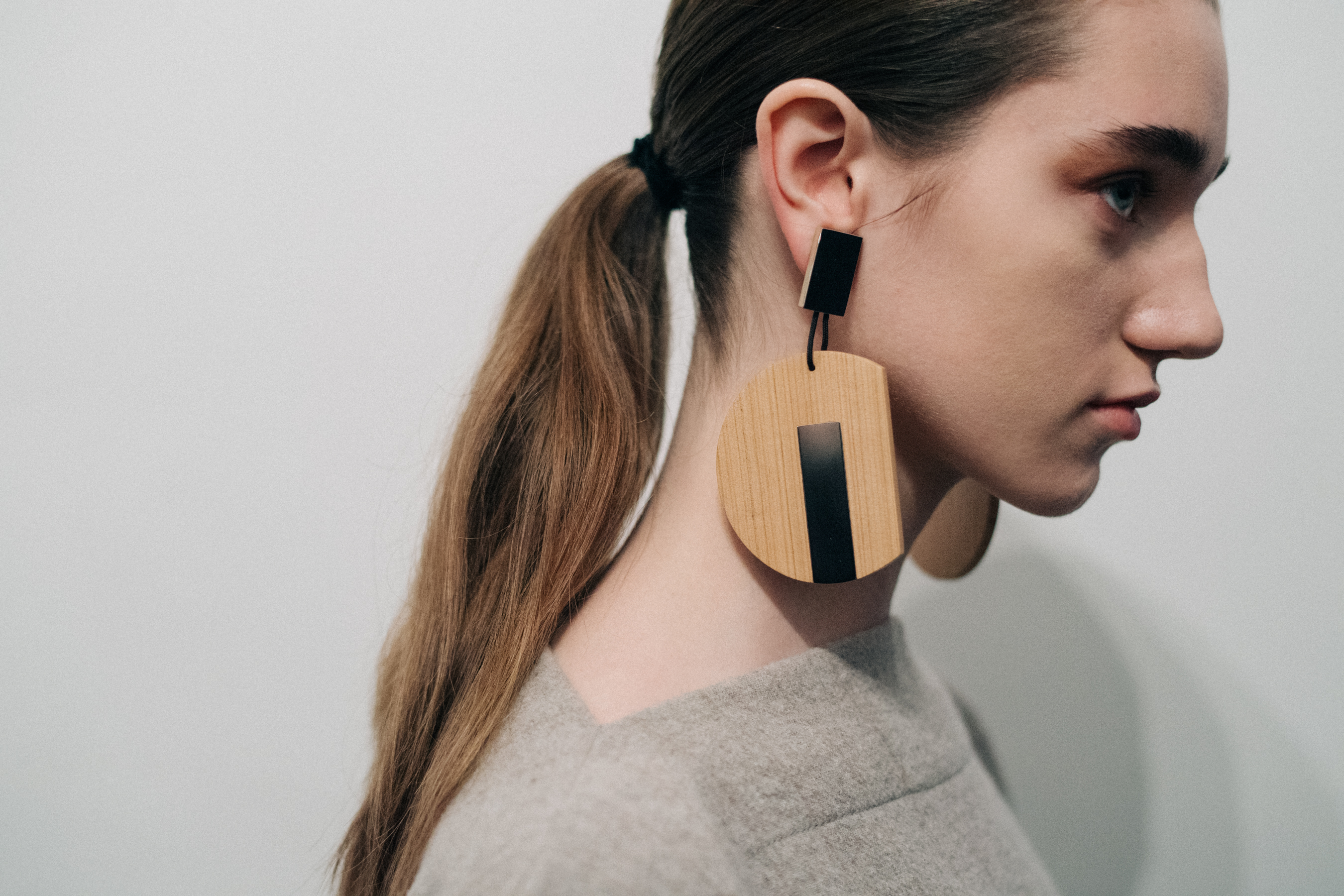 Model wearing wooden Nehera earrings