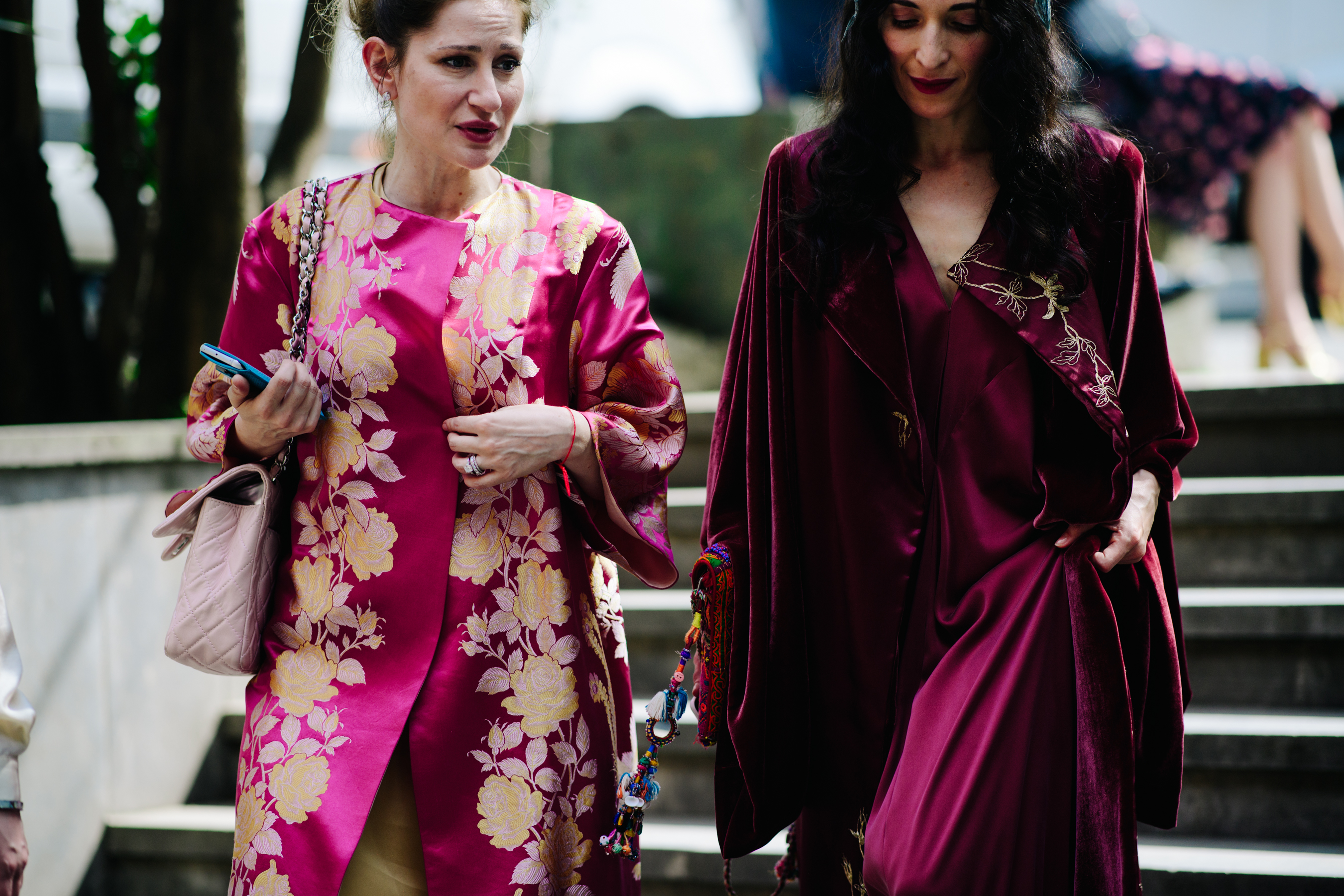 Two women wearing crimson silk outfits