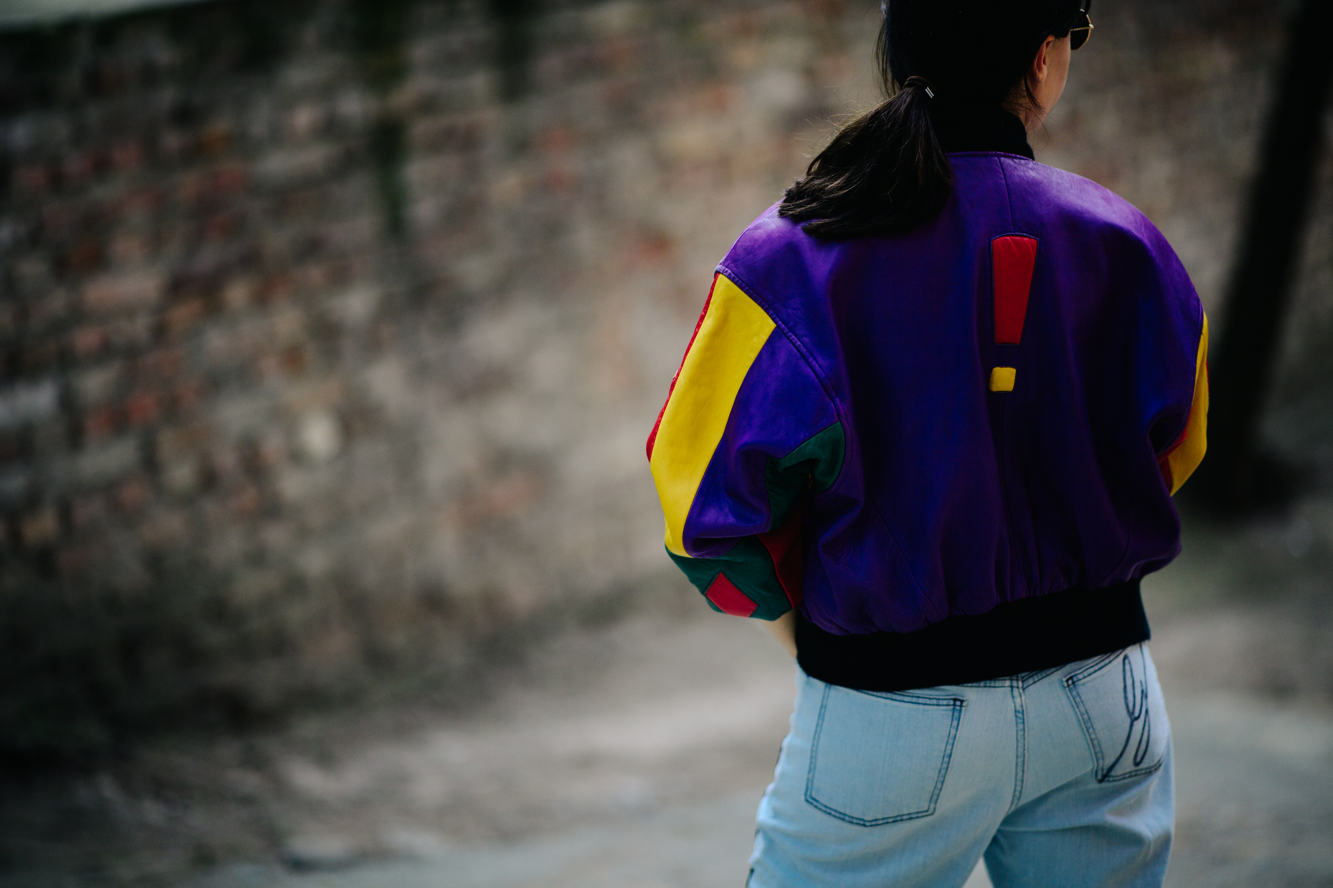 Girl wearing a multi-coloured bomber jacket